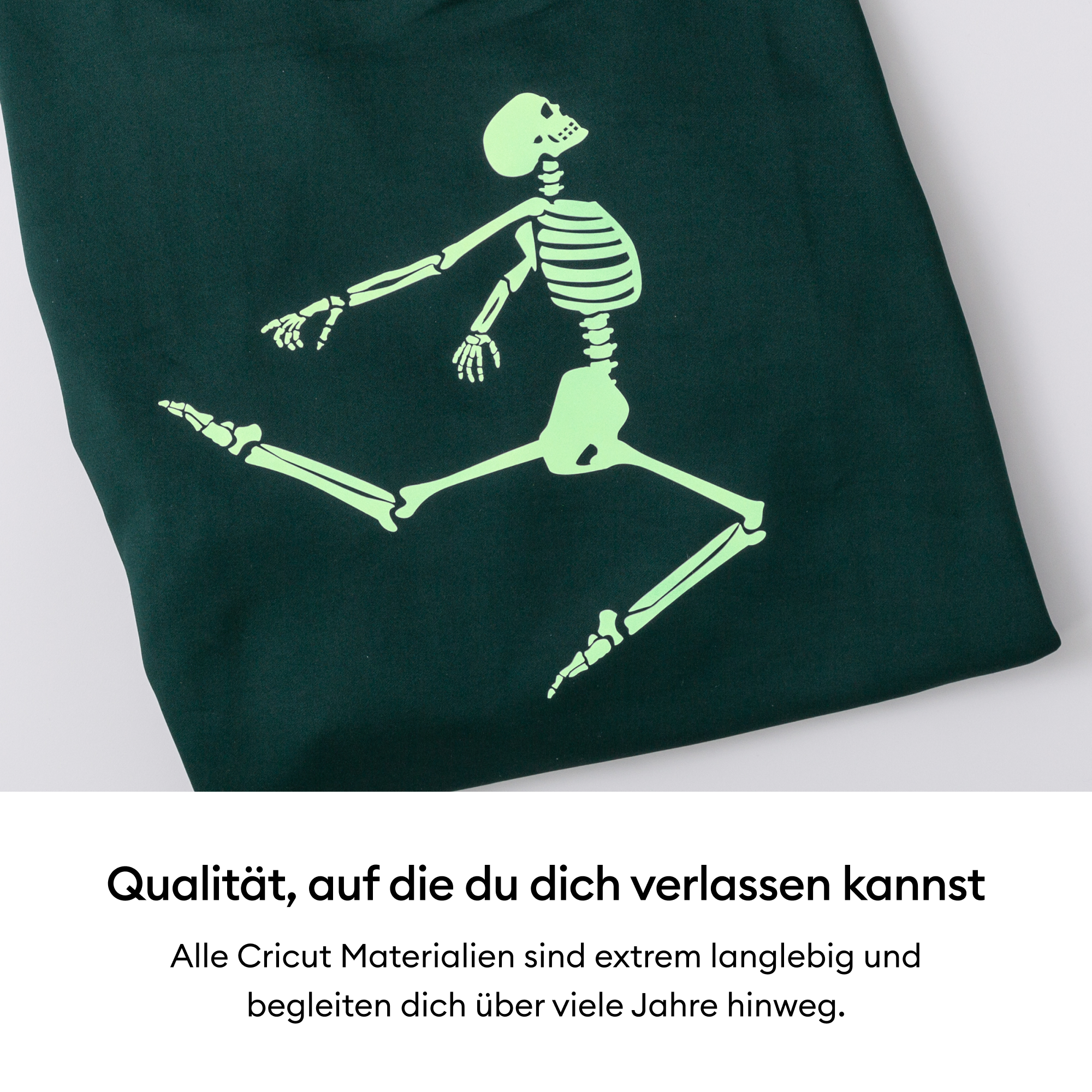 Grüner Stoff mit einem leuchtenden Skelettdesign. Weißer Hintergrund und Text unten.