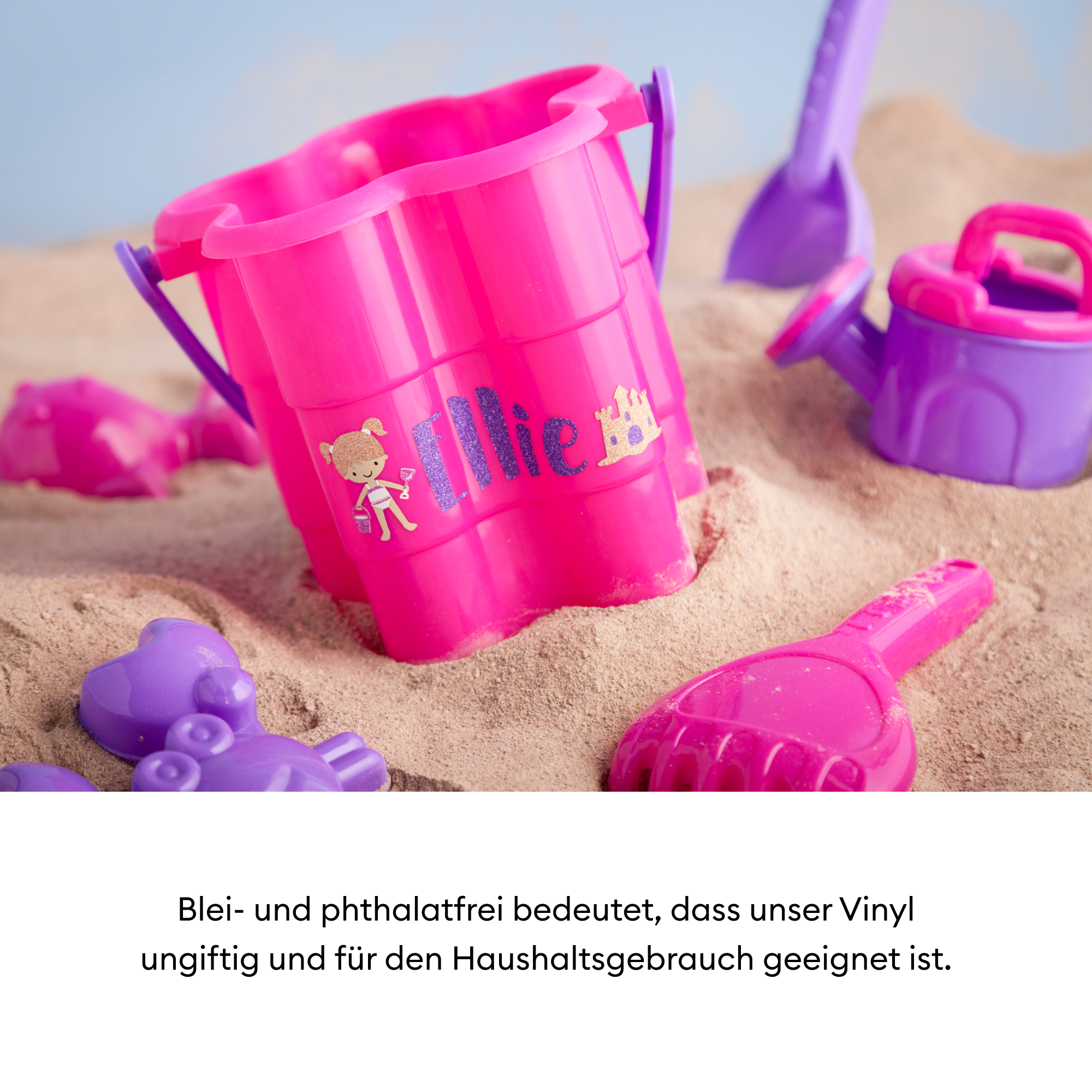 Pinkes Strandspielzeug: Eimer, Schaufel, Rechen, Gießkanne und Formen, auf Sand. Blauer Himmel im Hintergrund.