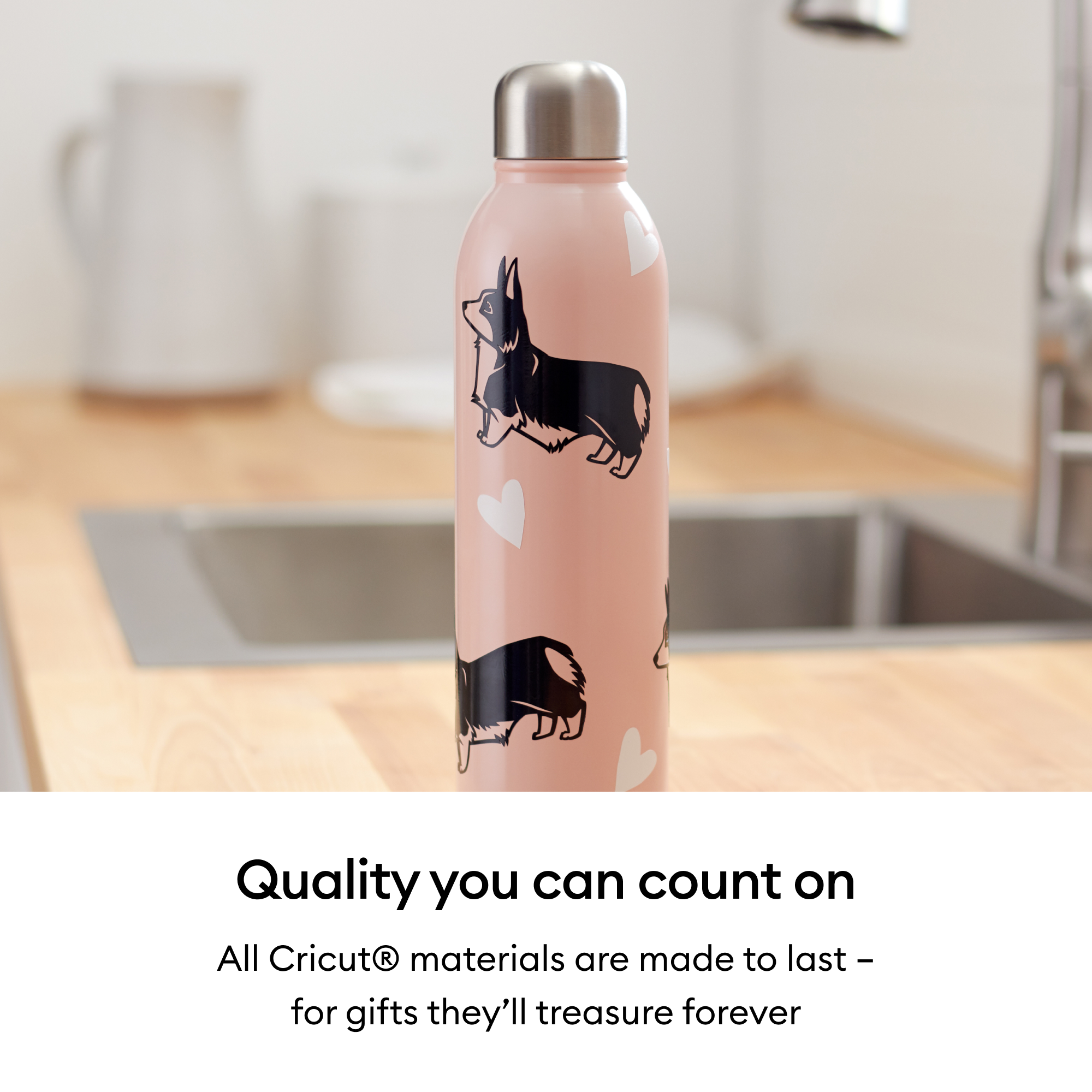 Rosa Wasserflasche mit Hunde- und Herzmustern, auf einer Holztheke, mit Spüle und weißem Krug im Hintergrund.