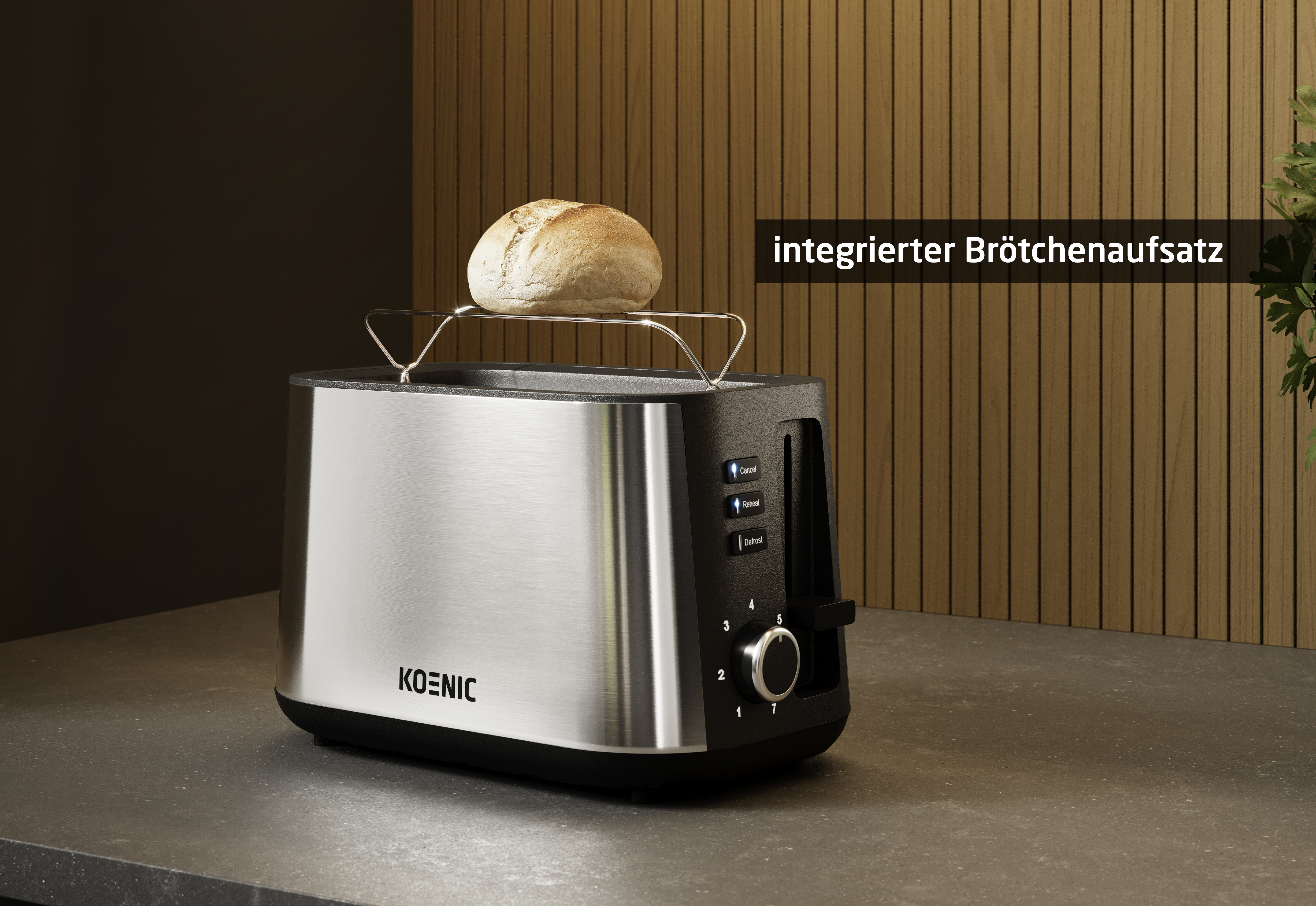 Ein Toaster aus Edelstahl mit einem Brötchen oben drauf. Er hat eine schwarze Ober- und Unterseite. Die Marke ist 'KOENIC'.