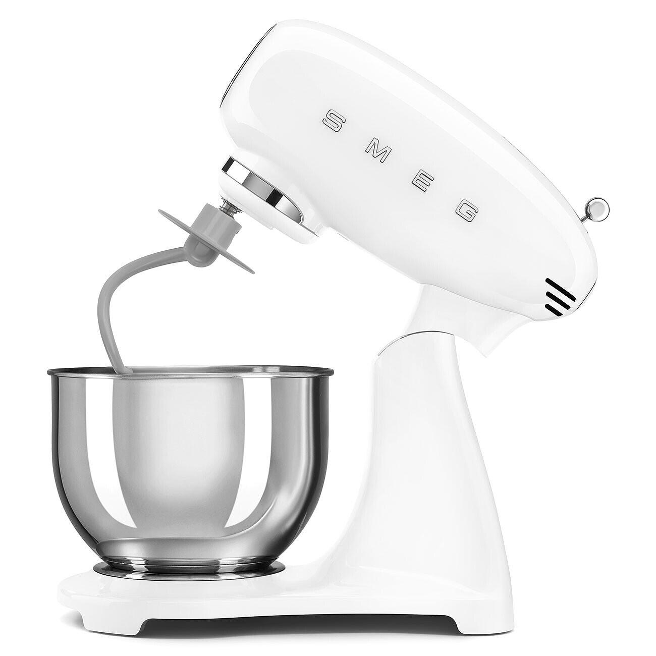 Ein weißer SMEG-Küchenmixer mit einer Edelstahlschüssel und grauen Aufsätzen. Der Mixer steht auf einer weißen Oberfläche.