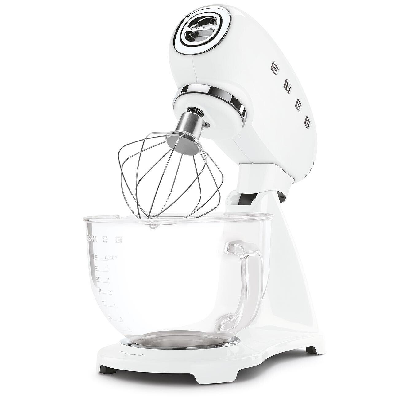 Ein weißer Küchenmixer mit einer Glasschüssel und einem Schneebesenaufsatz, vor weißem Hintergrund.
