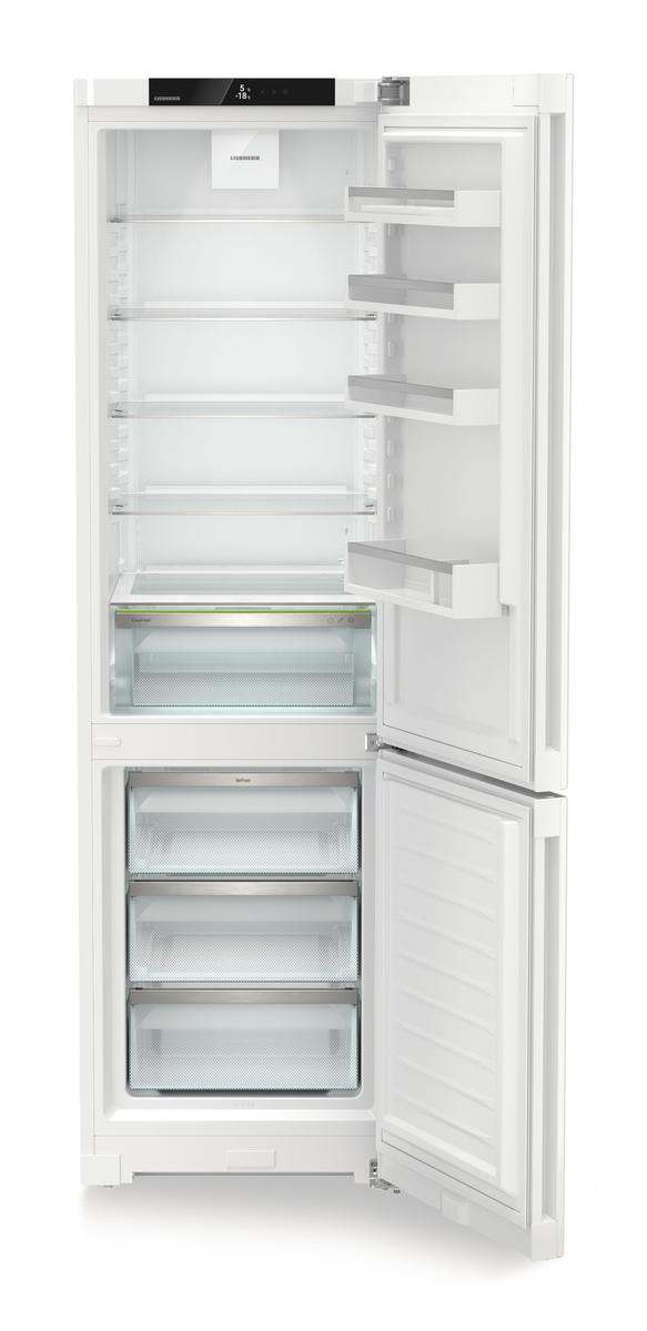Ein weißer Kühlschrank ist geöffnet und zeigt Regale, Schubladen und eine offene Gefriertür. Der Innenraum ist hell mit klaren Regalen.