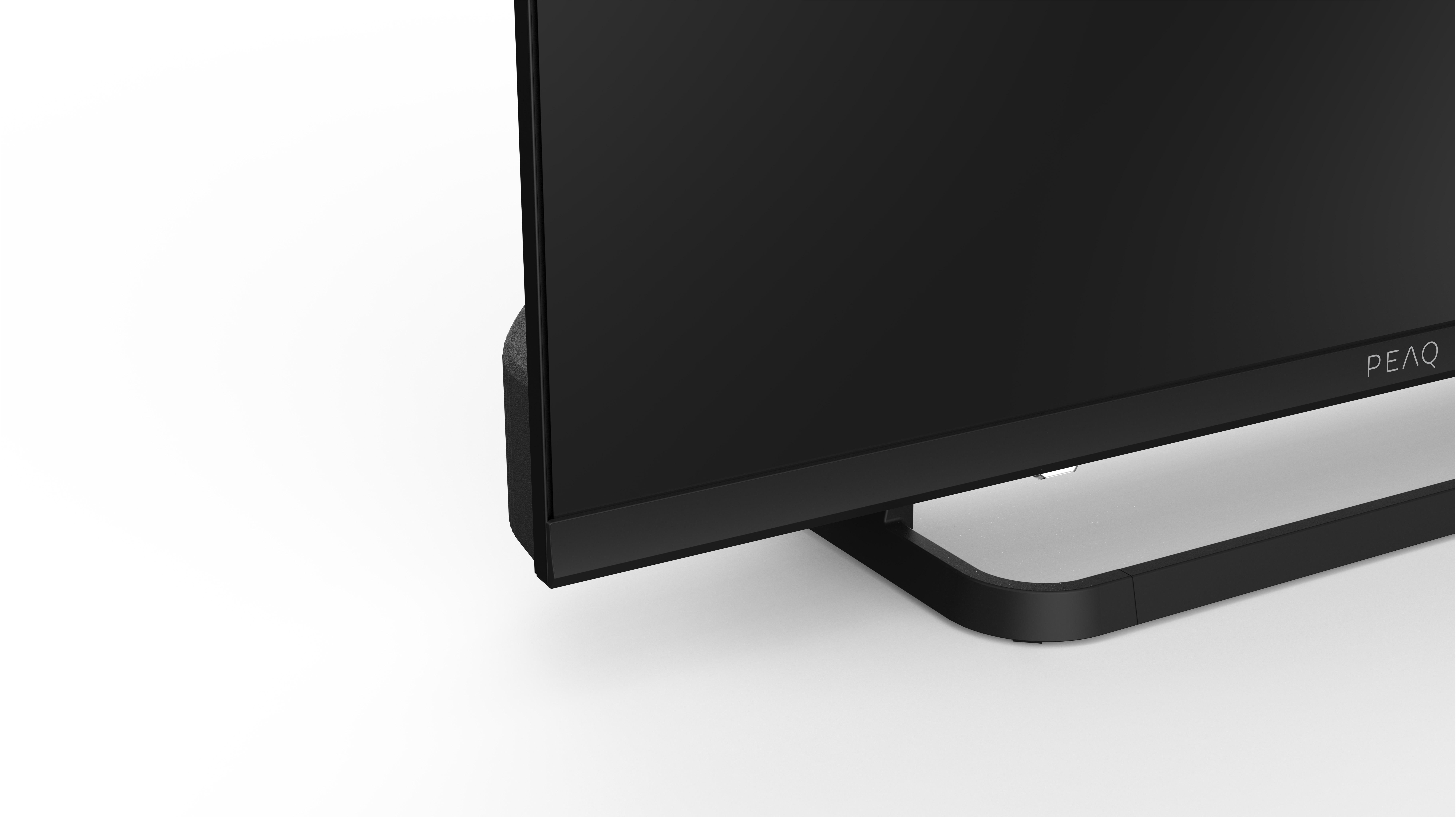 Nahaufnahme eines schwarzen Monitors mit gebogenem Fuß. Der Hintergrund ist weiß. Der Markenname PEAQ ist sichtbar.