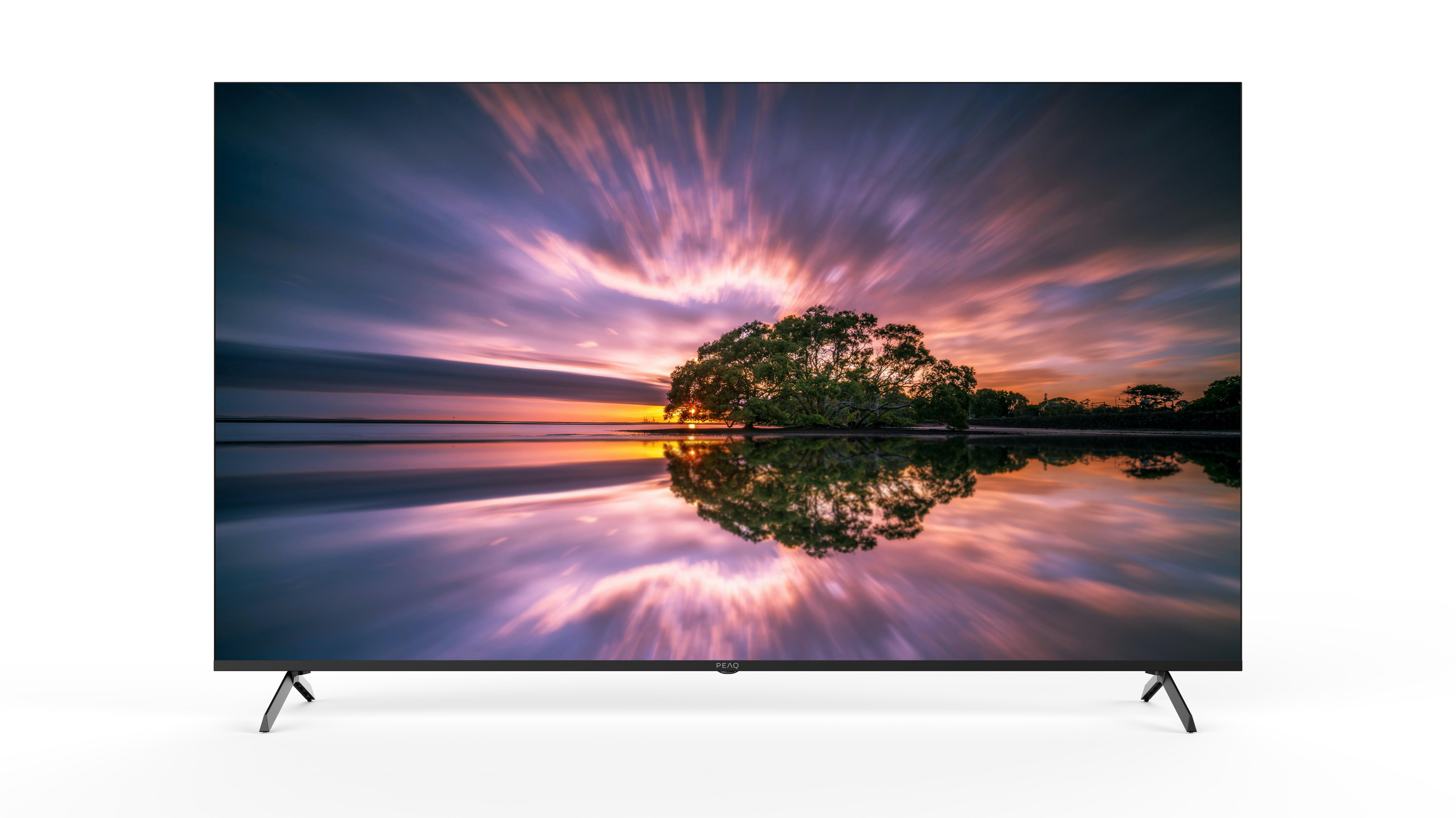 Der Fernsehbildschirm zeigt einen Sonnenuntergang über dem Wasser mit einem Baum in der Mitte. Spiegelungen bilden den Himmel und den Baum ab.