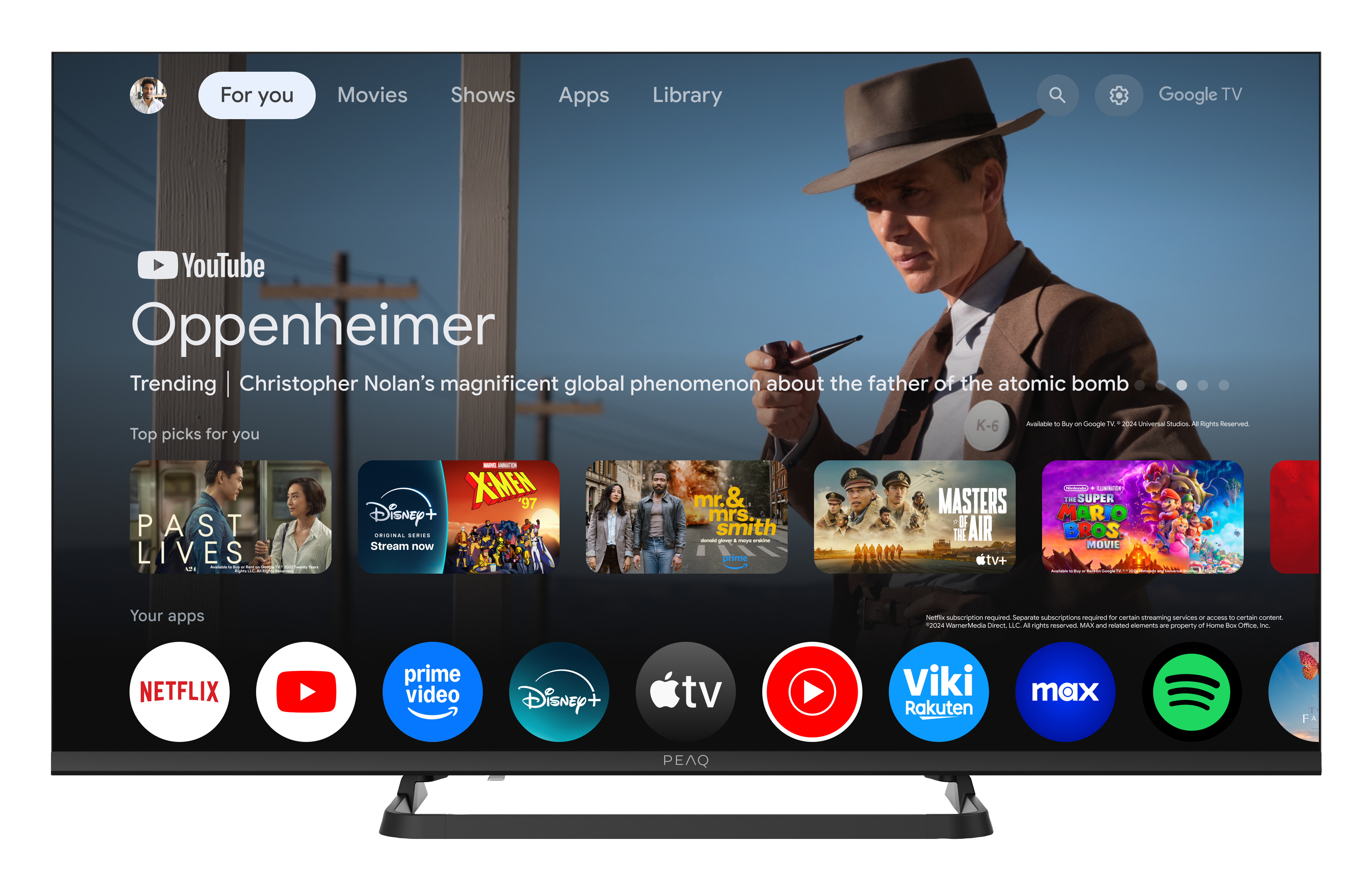 Der Fernsehbildschirm zeigt YouTube, den Film Oppenheimer und App-Symbole. Oben rechts ist ein Mann mit Hut zu sehen.