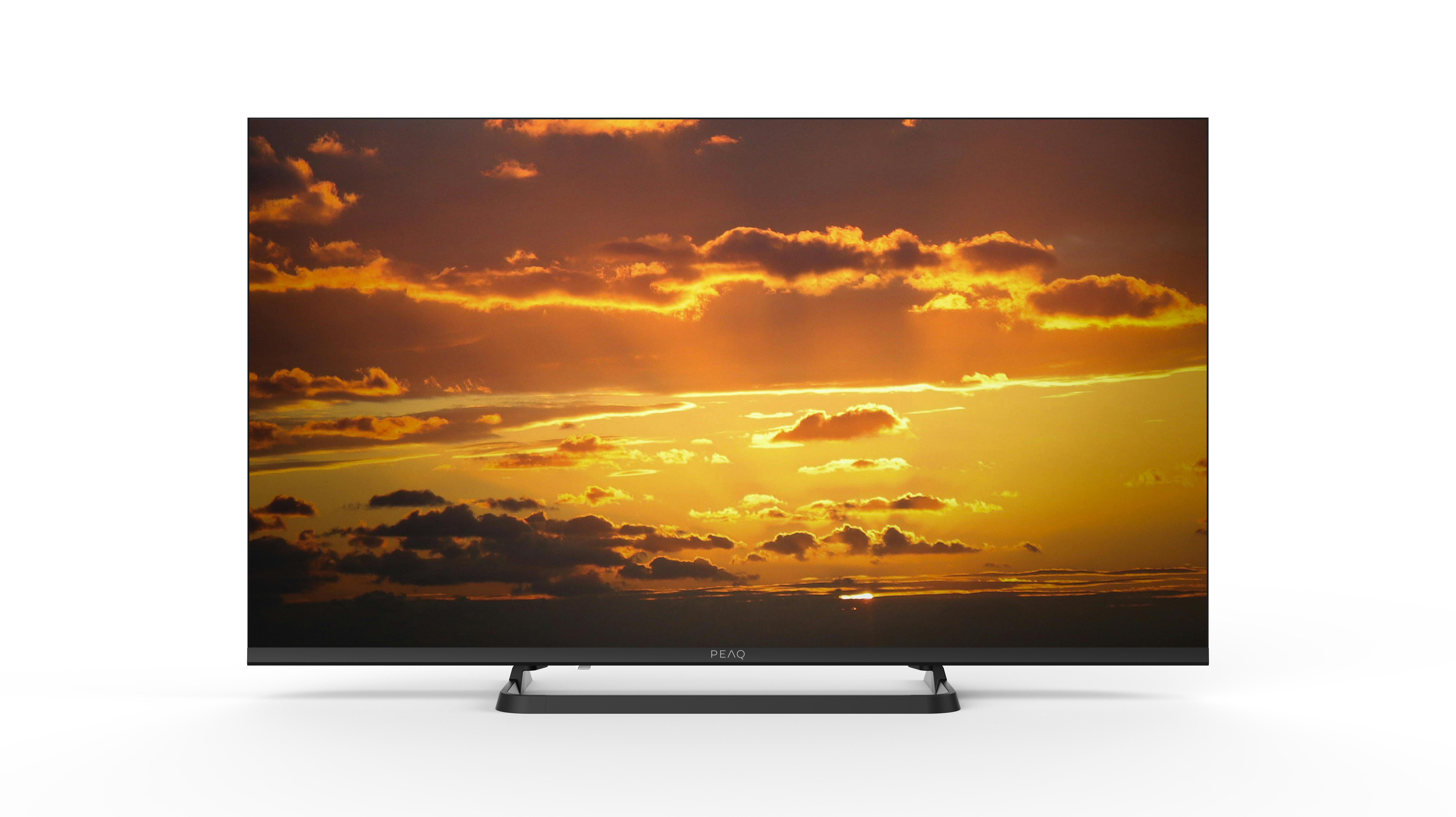Ein Fernseher zeigt einen Sonnenuntergang mit orangefarbenen, gelben und dunklen Wolken. Der Fernseher ist schwarz und hat ein PEAQ-Logo.