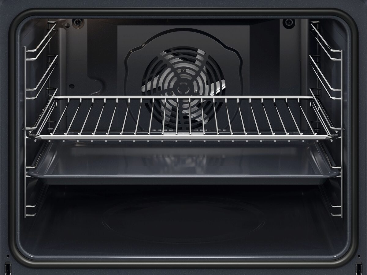 Interior de un horno. Se ve una rejilla metálica y una bandeja para hornear. Un ventilador en la parte trasera. El interior es negro.