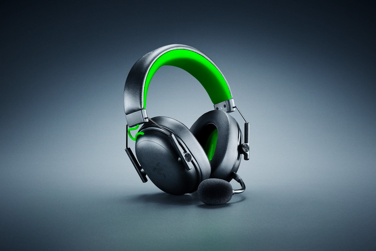 Schwarzes und graues Gaming-Headset mit grünen Akzenten. Enthält ein Mikrofon. Der Hintergrund ist ein Grauton.