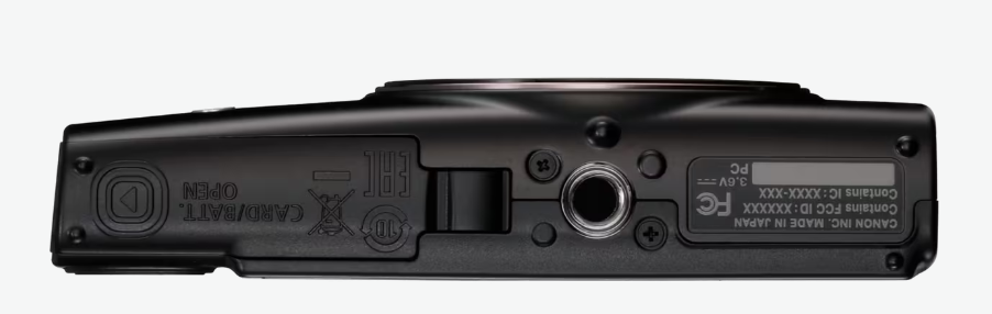 Widok spodniej części czarnego aparatu Canon, z różnymi portami, etykietami i drzwiczkami na baterię/kartę.