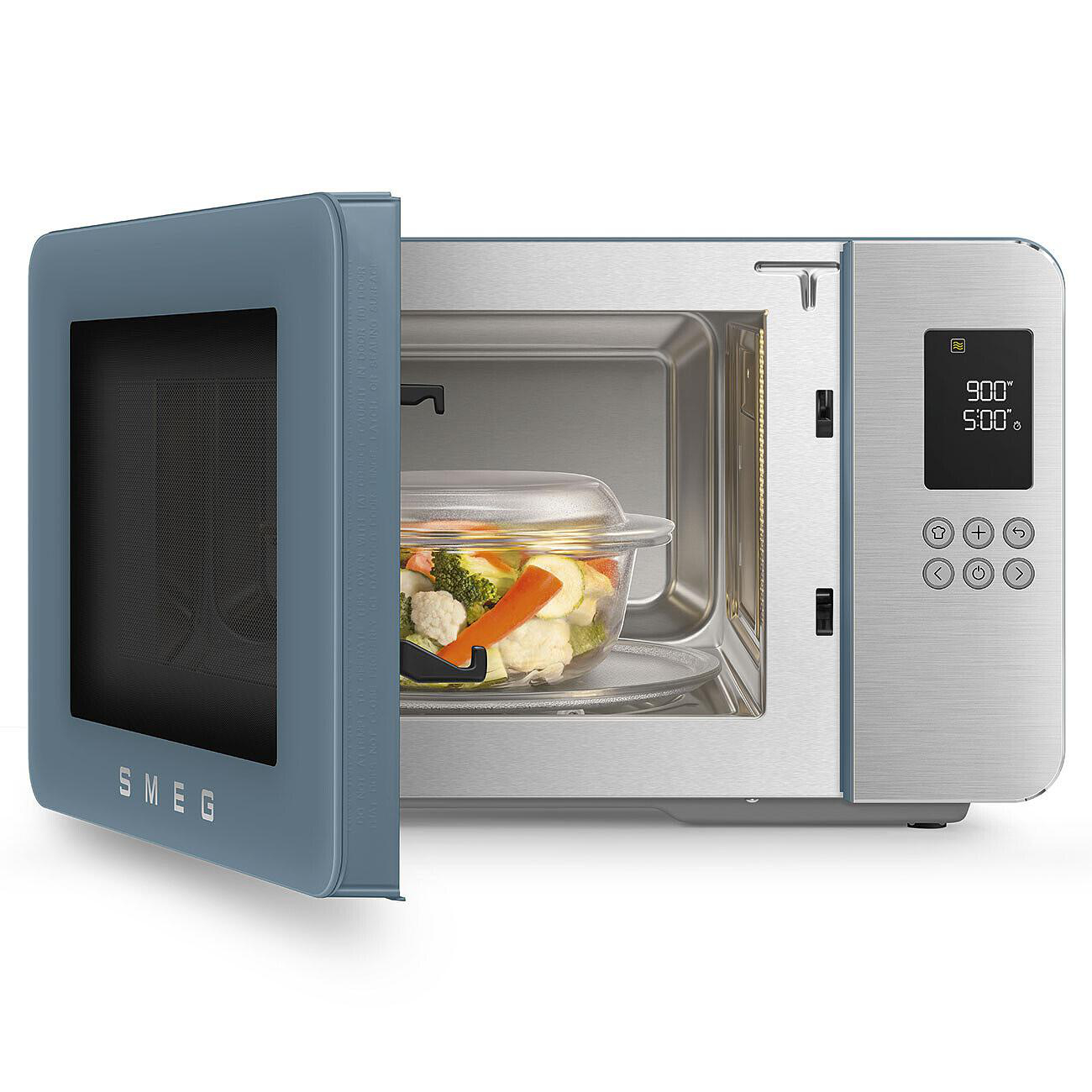 Offene blaue SMEG-Mikrowelle mit Glasschale mit Gemüse darin. Digitalanzeige zeigt 900 und 5:00. Edelstahl-Finish.