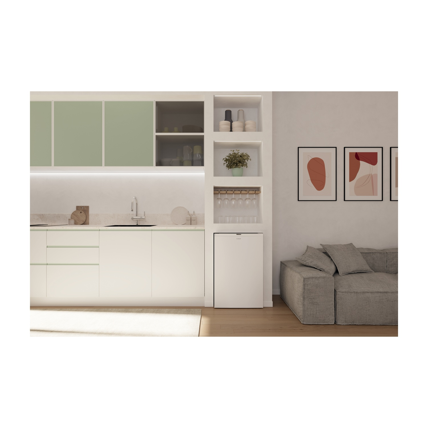 Cucina moderna con mobili bianchi, dettagli verdi e un piccolo frigorifero. Divano grigio a destra e opere d'arte sulla parete.