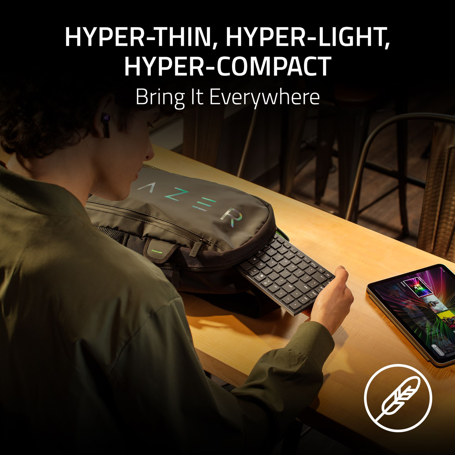A person holds a keyboard near a bag with the Razer logo. A tablet displays a colorful screen. Text reads: HYPER-THIN, HYPER-LIGHT.