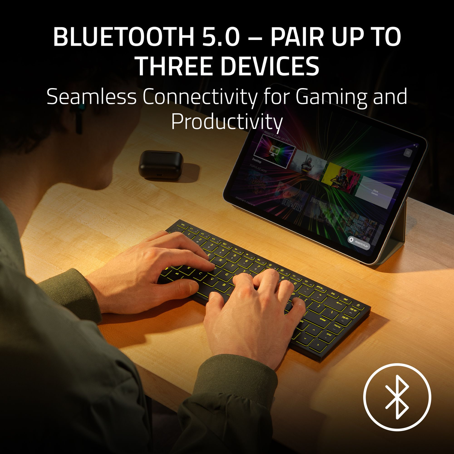 A person using a backlit keyboard, connected to a tablet, with Bluetooth logo. Text says: Bluetooth 5.0 - Pair up to Three Devices.