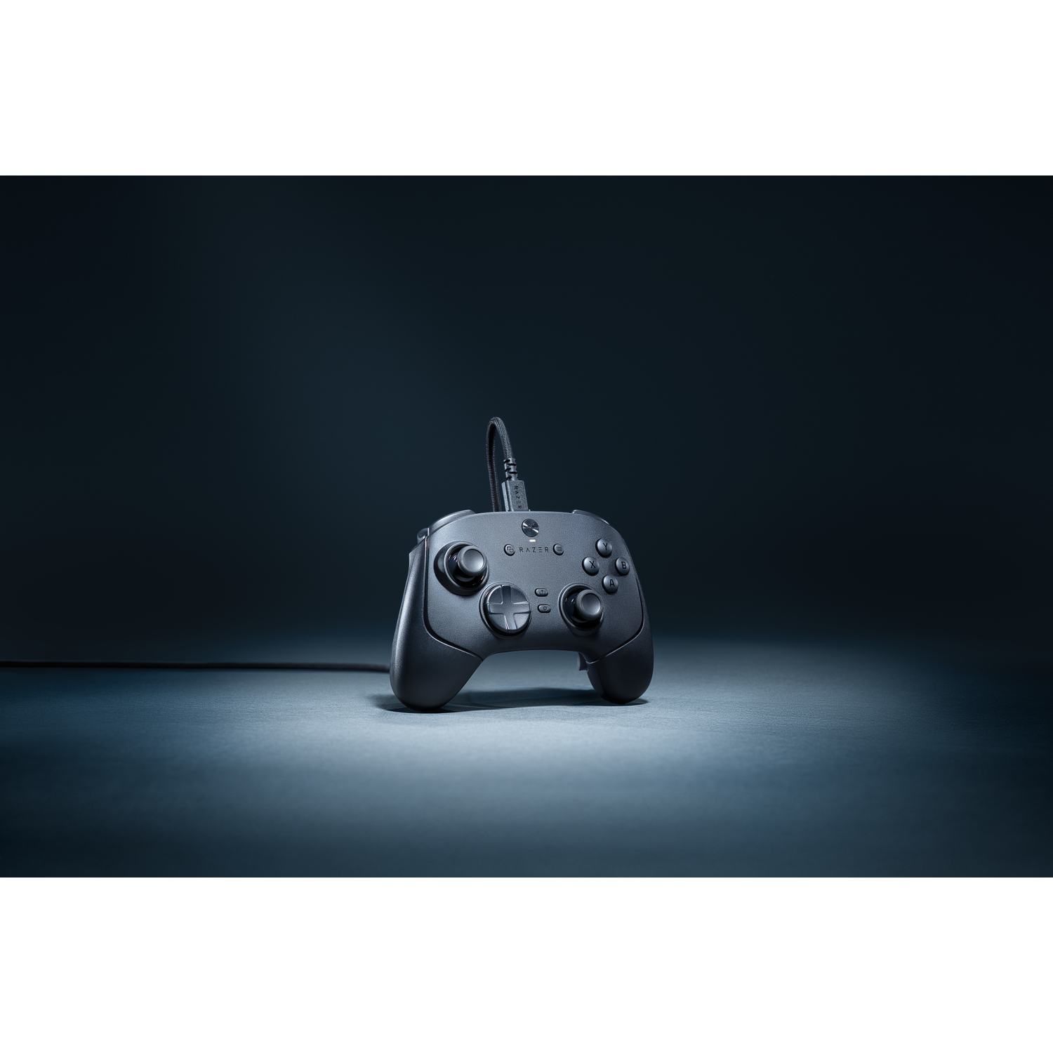 A black Razer gamepad is centered on a surface. It has buttons and sticks. A cable extends upwards from the controller.
