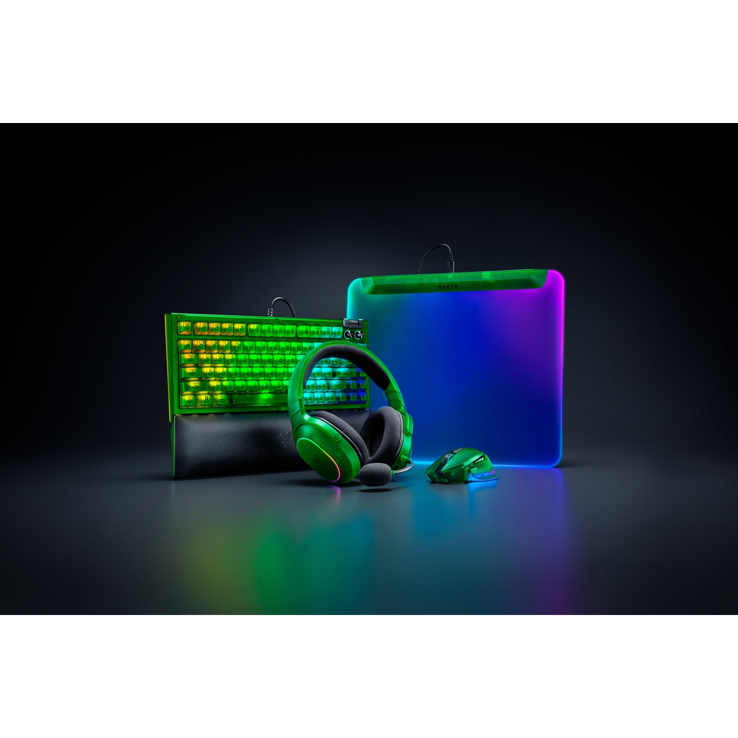 Gaming setup: toetsenbord, headset, muis en een pad, allemaal in groen en zwart met kleurrijke lichten. Donkere achtergrond en reflecterend oppervlak.