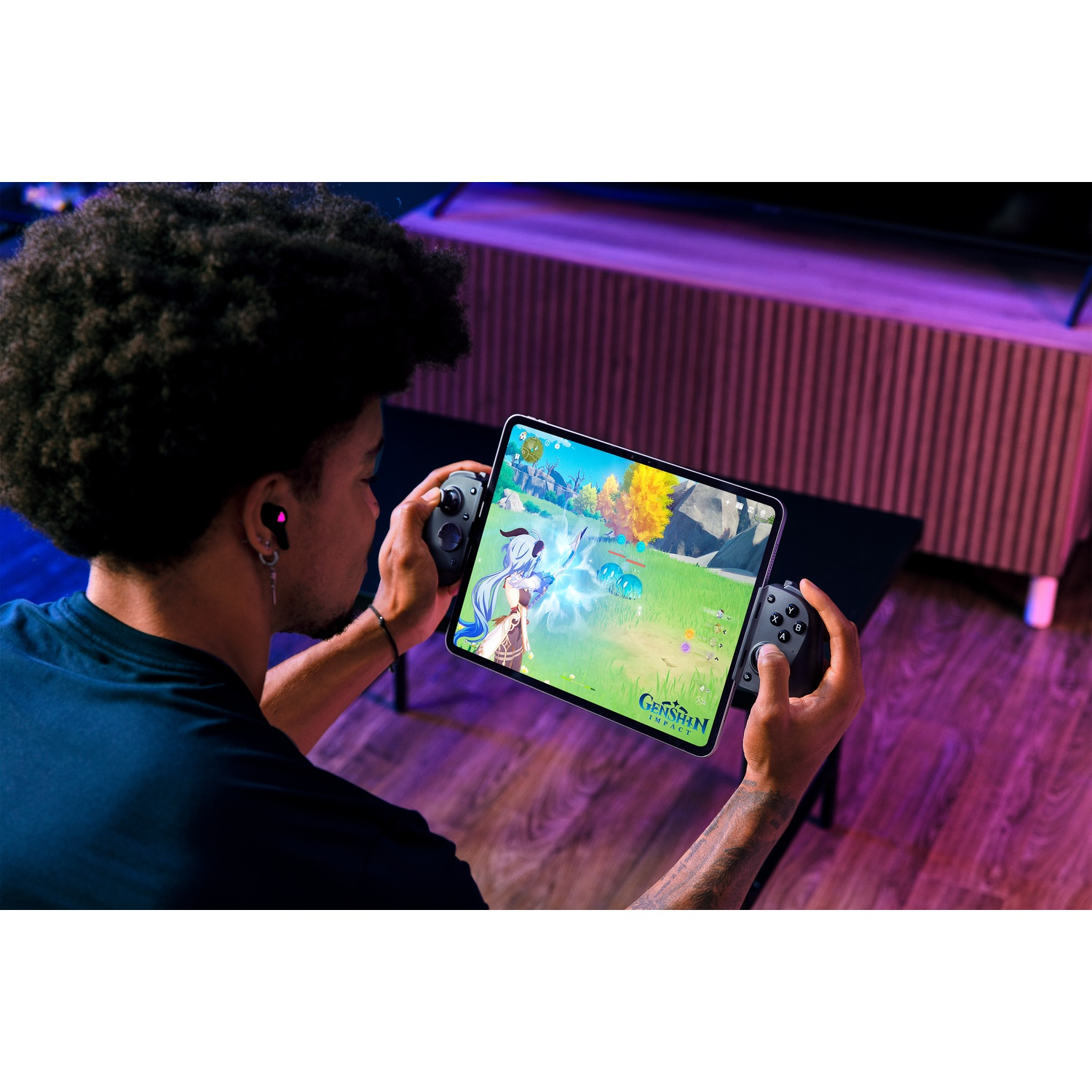 Een persoon met een koptelefoon speelt een videospel op een tablet met een controller. De interface van het spel is zichtbaar.