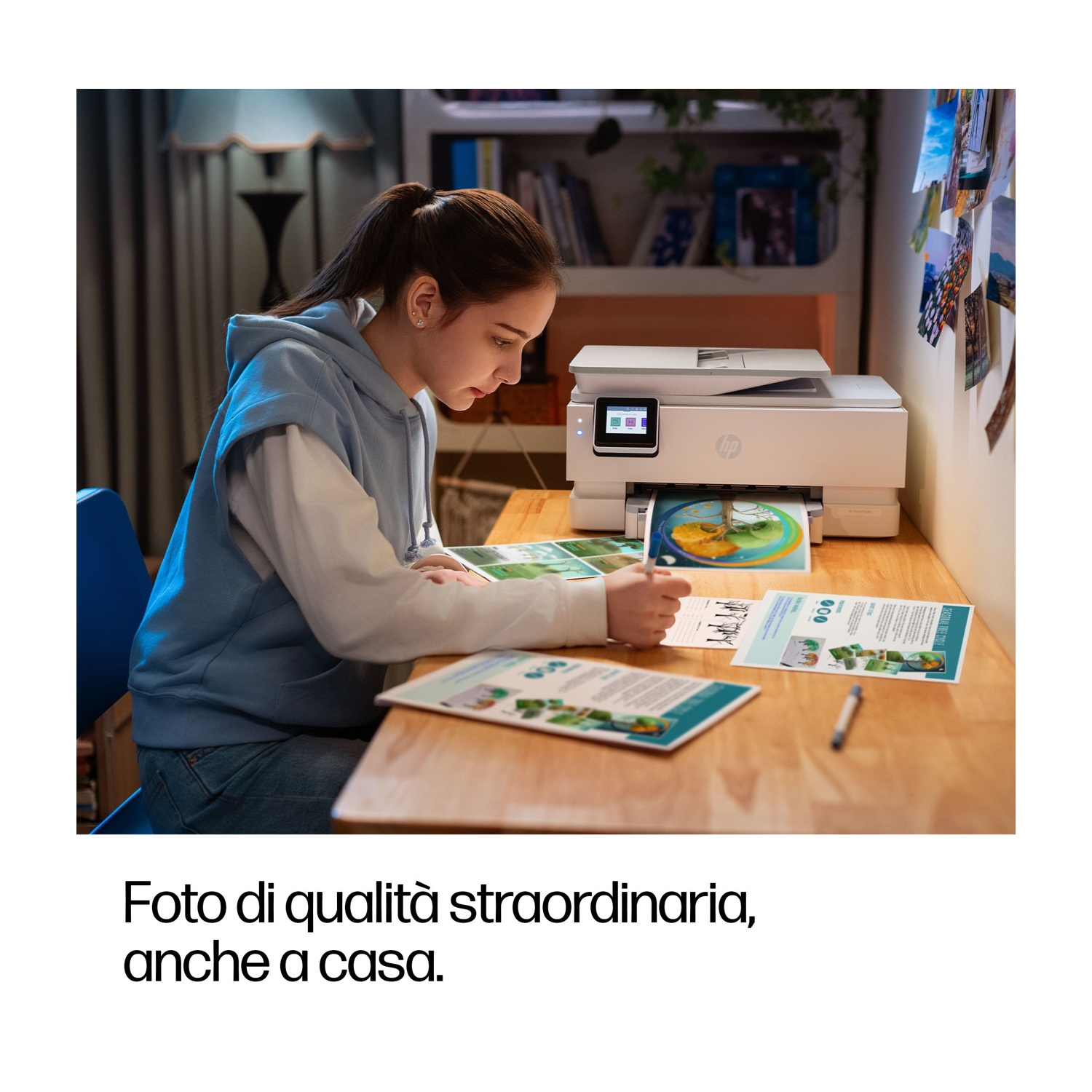 Una giovane donna scrive, seduta a una scrivania. Una stampante HP è sulla scrivania. Documenti stampati e una penna sono visibili.