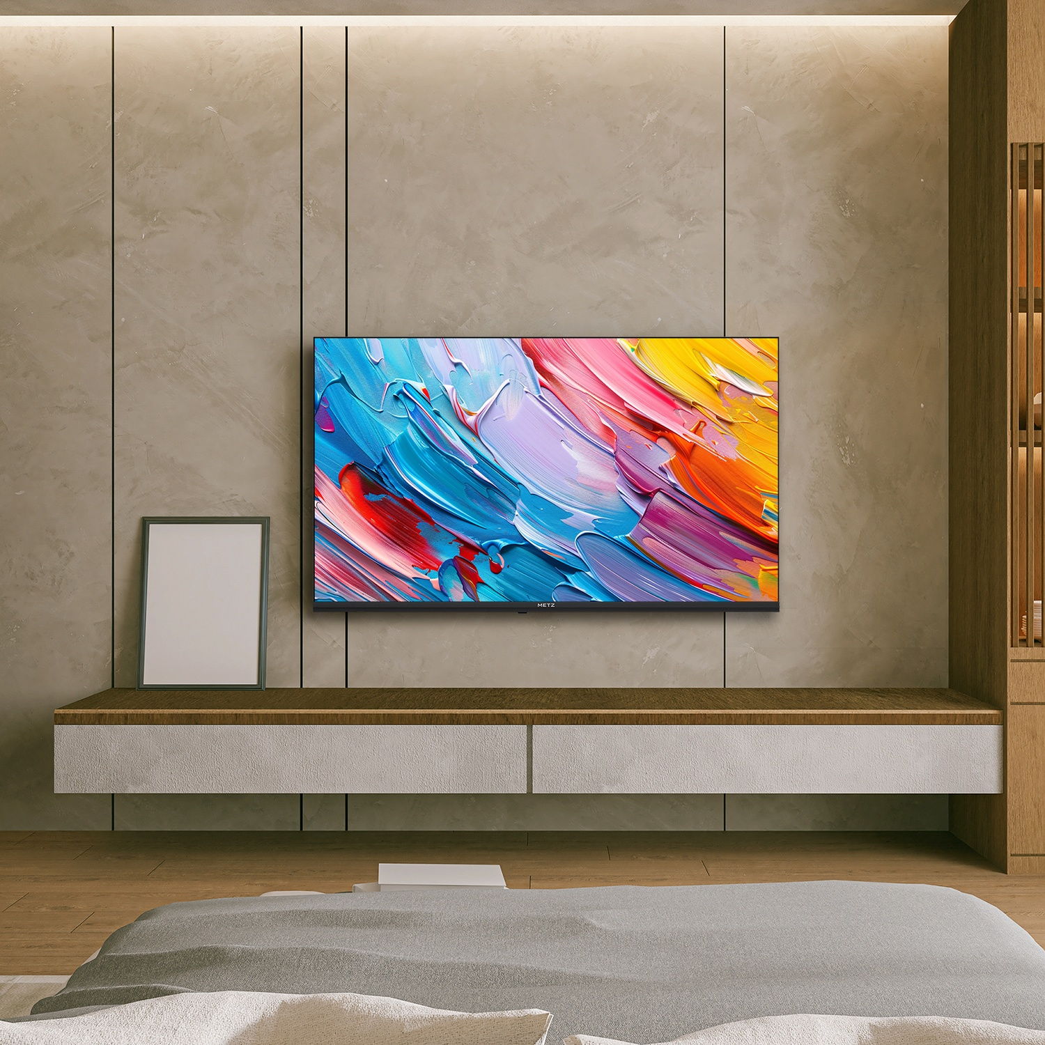 Soggiorno con TV che mostra arte astratta colorata, un'immagine incorniciata e un letto. Il muro è beige e il pavimento in legno.