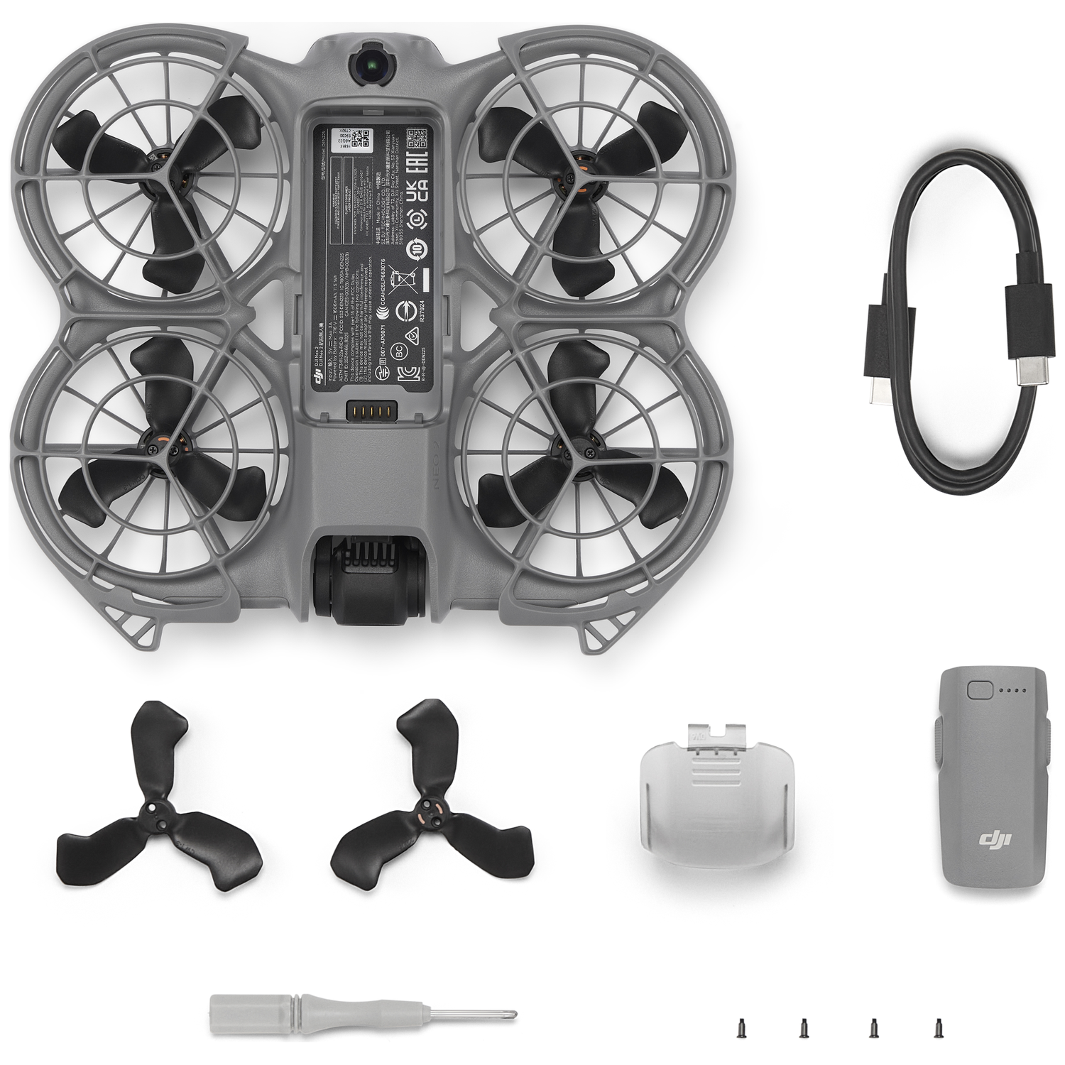 Drone-onderdelen, waaronder de body, propellers, oplader, schroevendraaier, schroeven en batterij, op een wit oppervlak.