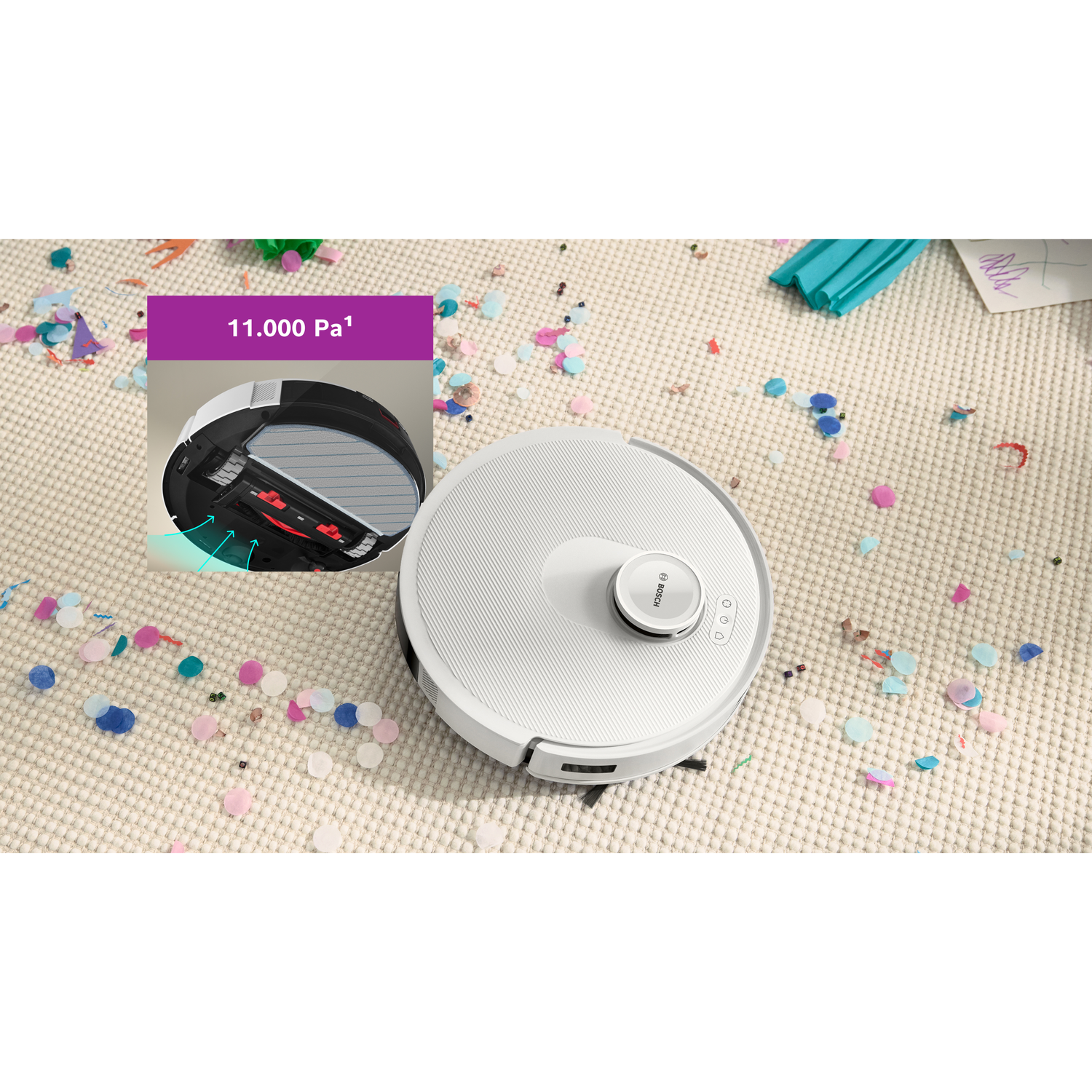A white robot vacuum cleaner on a beige carpet scattered with confetti. An inset shows the vacuum's underside and suction power.
