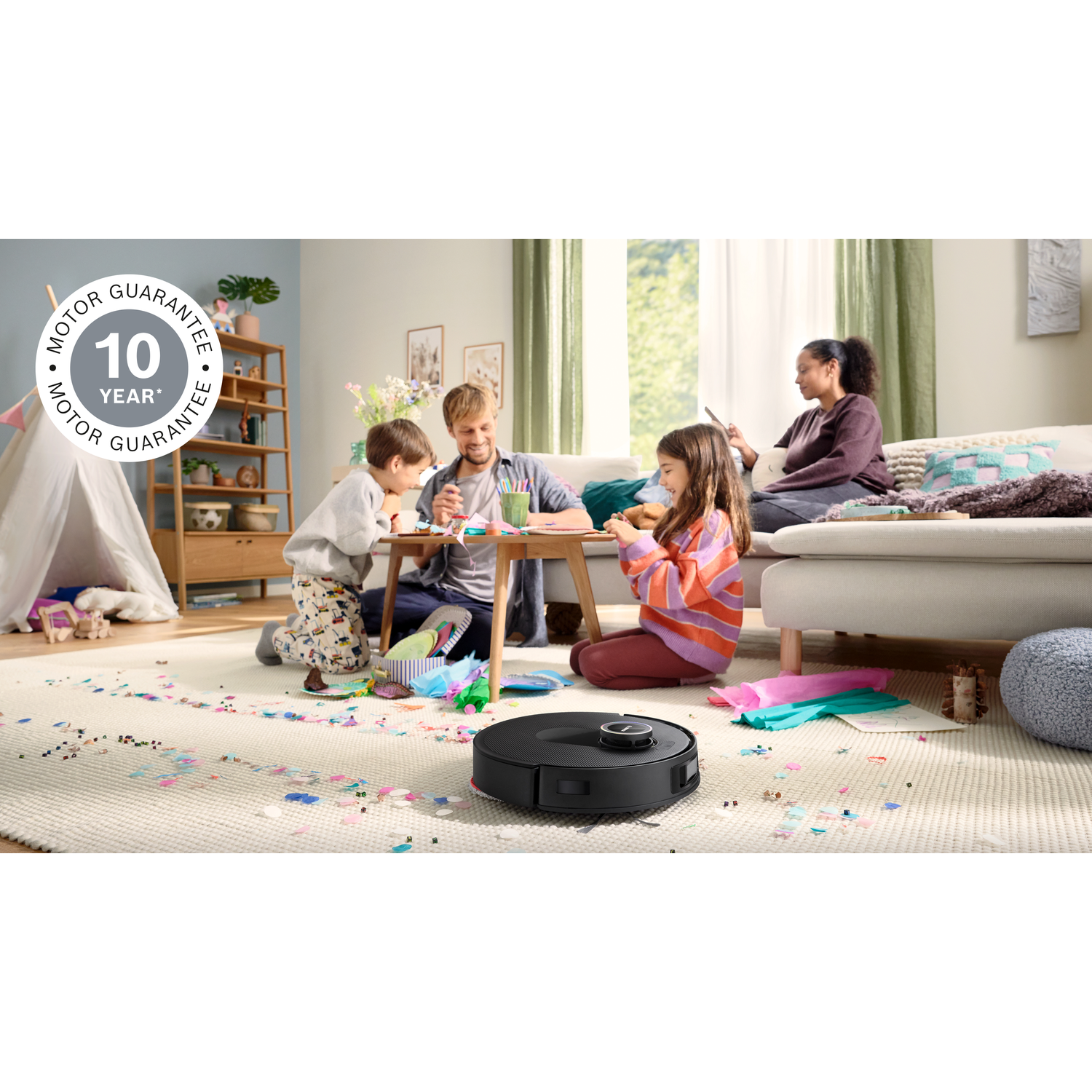 Family crafts at home. A vacuum cleaner is on the floor. Children and parents are doing crafts and a woman is sitting on the sofa.
