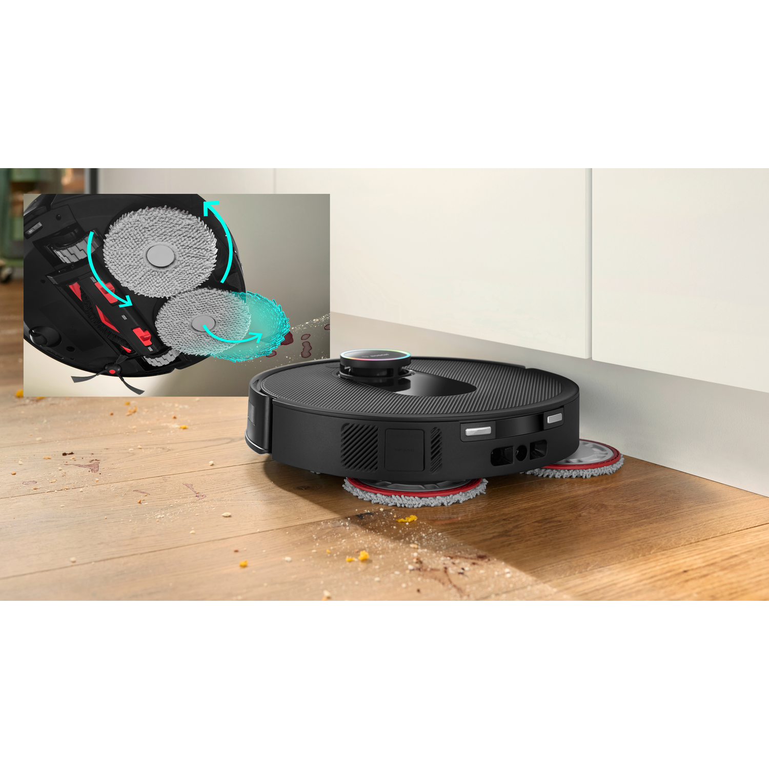 A black robot vacuum cleaner on a wooden floor. It's cleaning, with an inset showing its cleaning mechanism and the floor's debris.