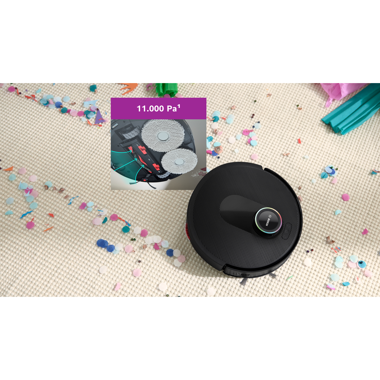 A black robot vacuum cleaner on a beige carpet scattered with confetti. An inset shows the cleaning mechanism. Party decorations.