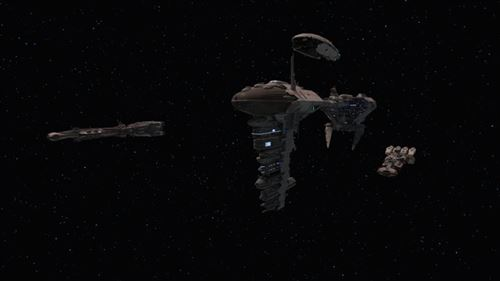 Estación espacial con naves estelares. Gran estructura en el centro, naves a la izquierda y derecha, todo contra un fondo estrellado.