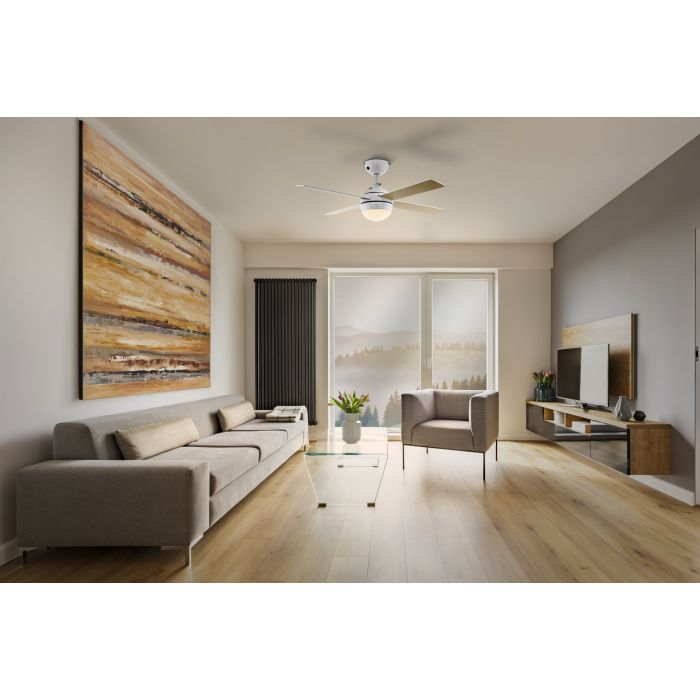 Wohnzimmer mit Sofa, Sessel, Fernseher und Deckenventilator. Ein großes Gemälde hängt an der Wand, und durch das Fenster ist ein Blick auf Berge zu sehen.