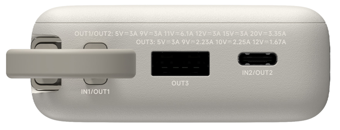 Egy világosszürke power bank közelképe. Több IN1, OUT1, OUT2 és OUT3 feliratú portja van. A szöveg feszültséget és áramerősséget ad meg.