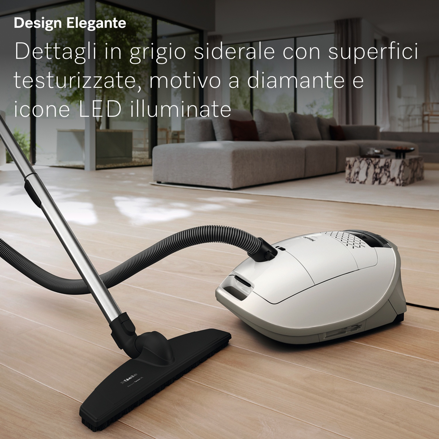 Un aspirapolvere bianco con tubo e testina neri è su un pavimento in legno in un soggiorno moderno.