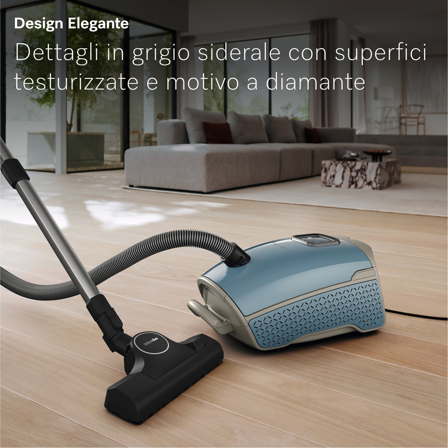 Un aspirapolvere blu su pavimento in legno. Un divano e un tavolo sullo sfondo.