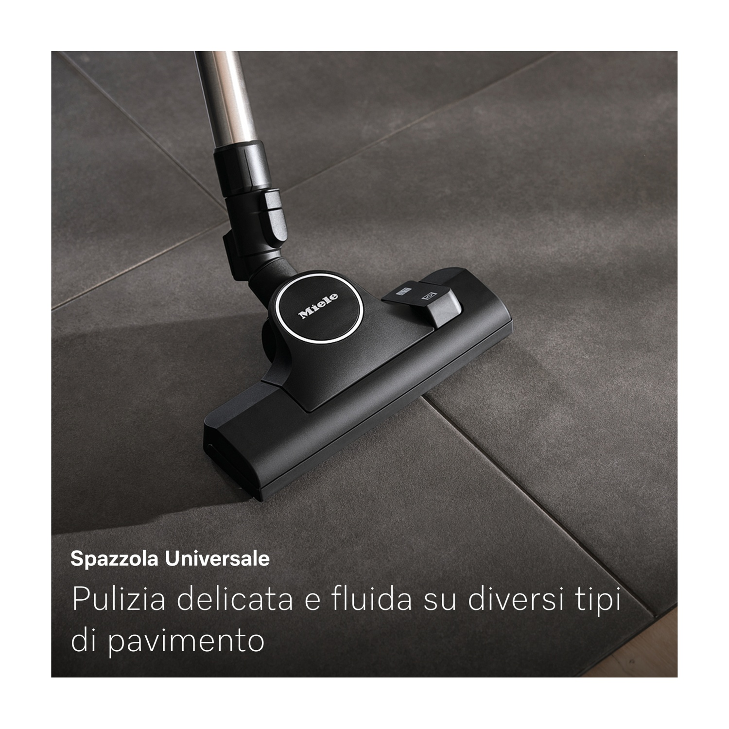 Testa di aspirapolvere Miele nera su piastrelle grigie. L'aspirapolvere è etichettato 'Spazzola Universale'.