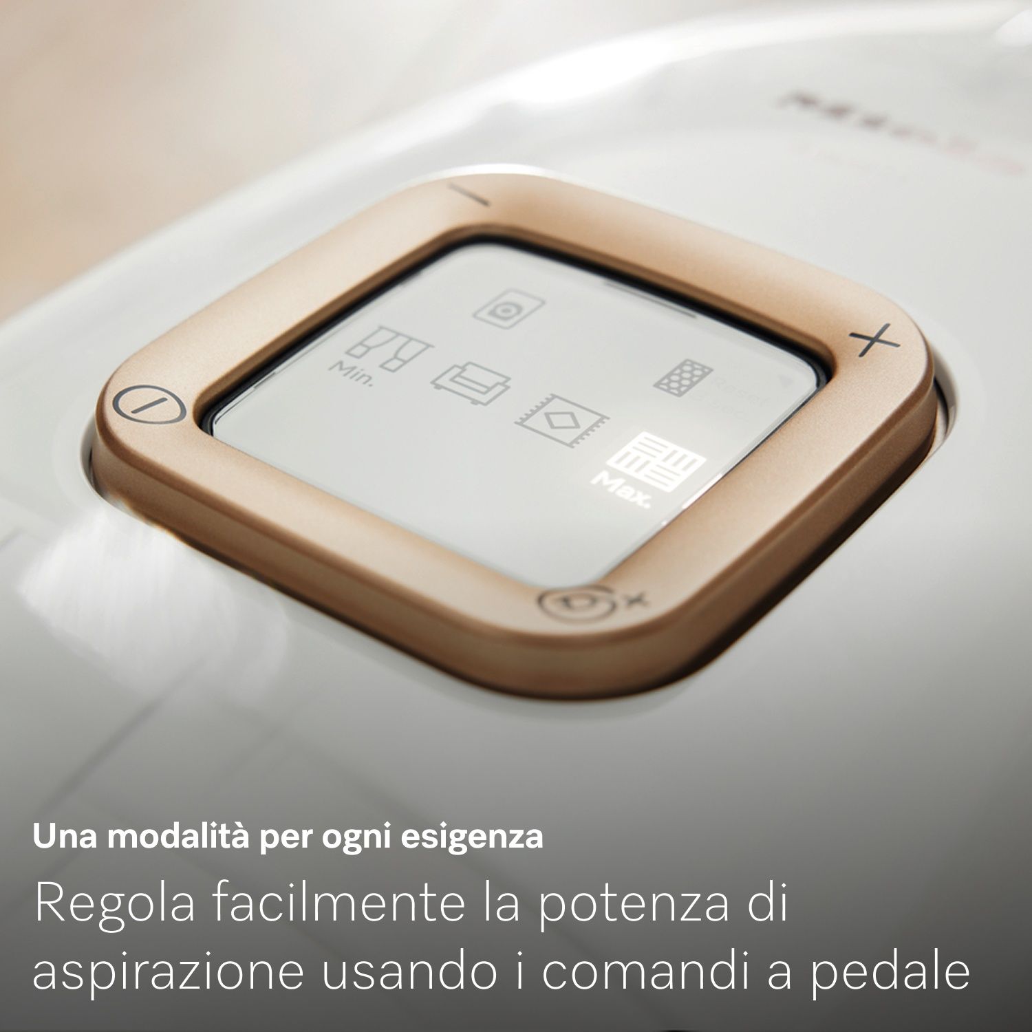 Primo piano del pannello di controllo di un aspirapolvere. Cornice dorata attorno a uno schermo con icone e pulsanti. Superficie bianca.
