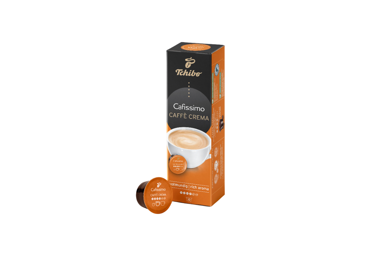 Siyah zemin üzerinde bir Tchibo Cafissimo Caffe Crema kutusu ve bir kahve kapsülü. Kutu turuncu ve siyah, kapsül kahverengi.