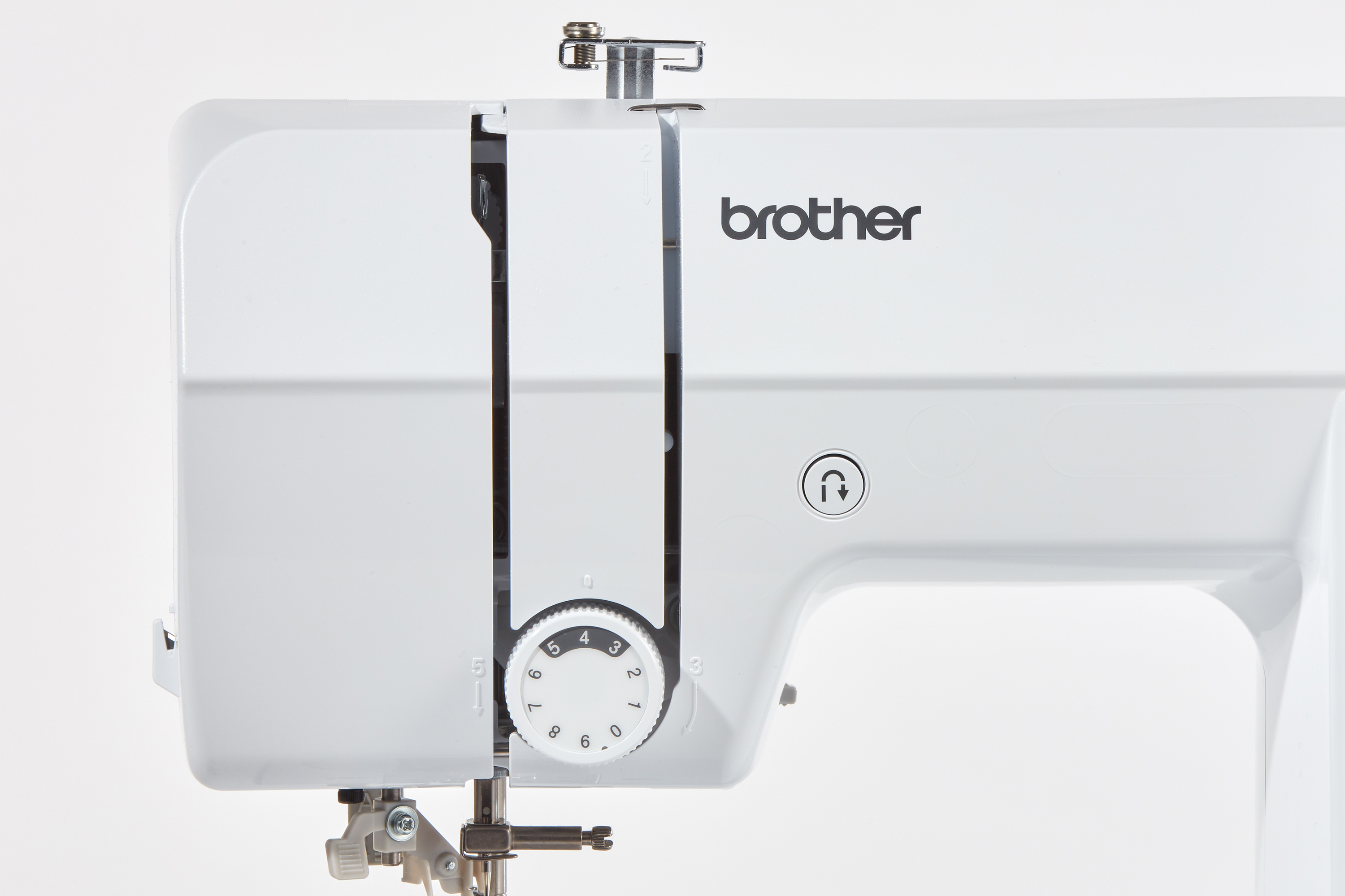 Nahaufnahme einer weißen Brother-Nähmaschine. Merkmale sind ein Drehknopf, der Markenname und ein Nadelmechanismus.
