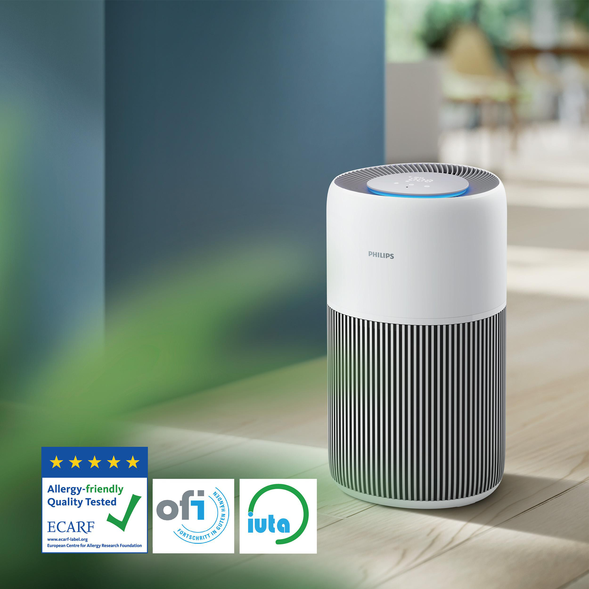 Ein weißer Philips Luftreiniger steht auf Holz. Er steht vor einer blauen Wand, mit Logos und einem verschwommenen Hintergrund.