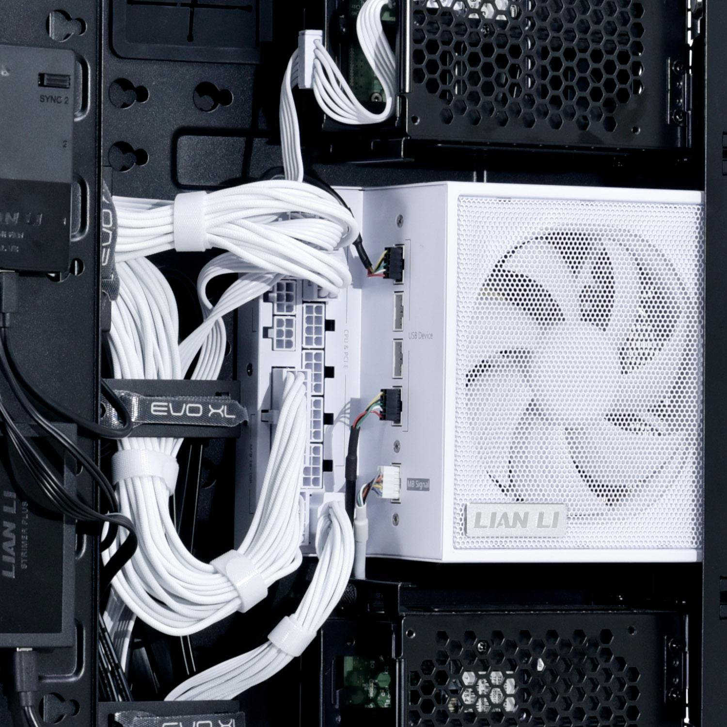 Im Inneren eines Computergehäuses sind ein weißes Netzteil und Kabel zu sehen. Schwarze Gehäusekomponenten und ein Lüfter sind ebenfalls vorhanden.