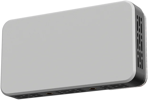Un appareil rectangulaire gris clair avec des coins arrondis. Il a une base noire avec des trous et un côté avec des fentes verticales.
