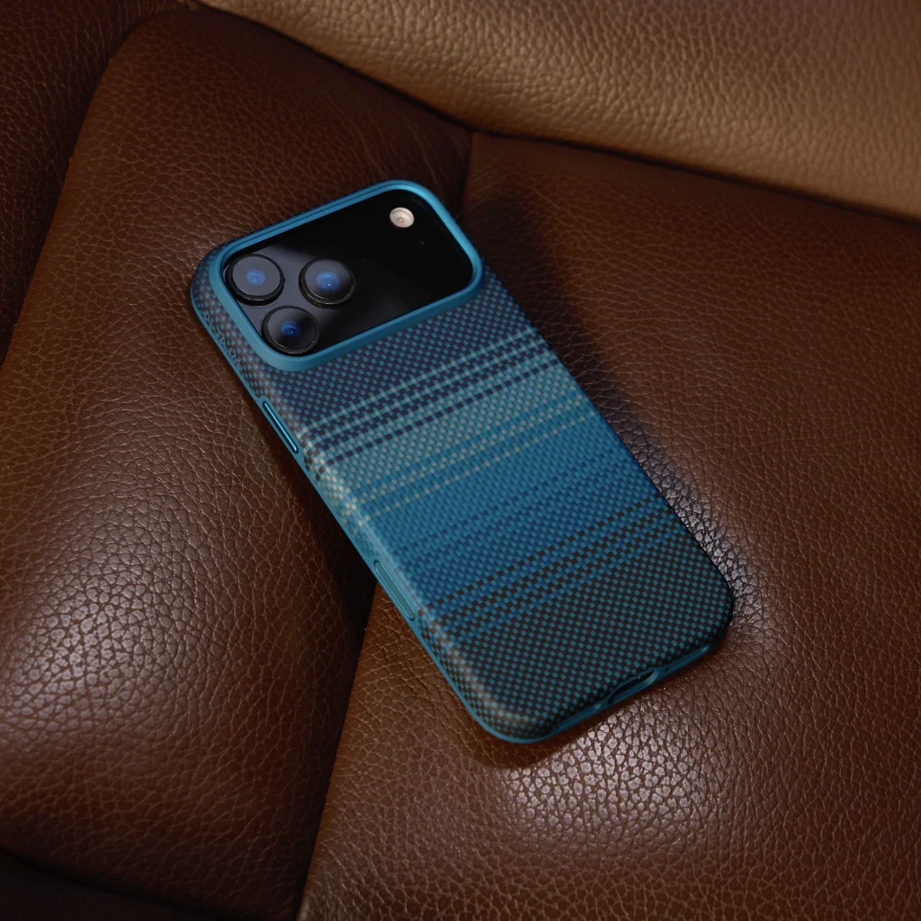 Egy kék mintás tokkal ellátott okostelefon barna bőr felületen fekszik. A telefon több lencsével rendelkezik.