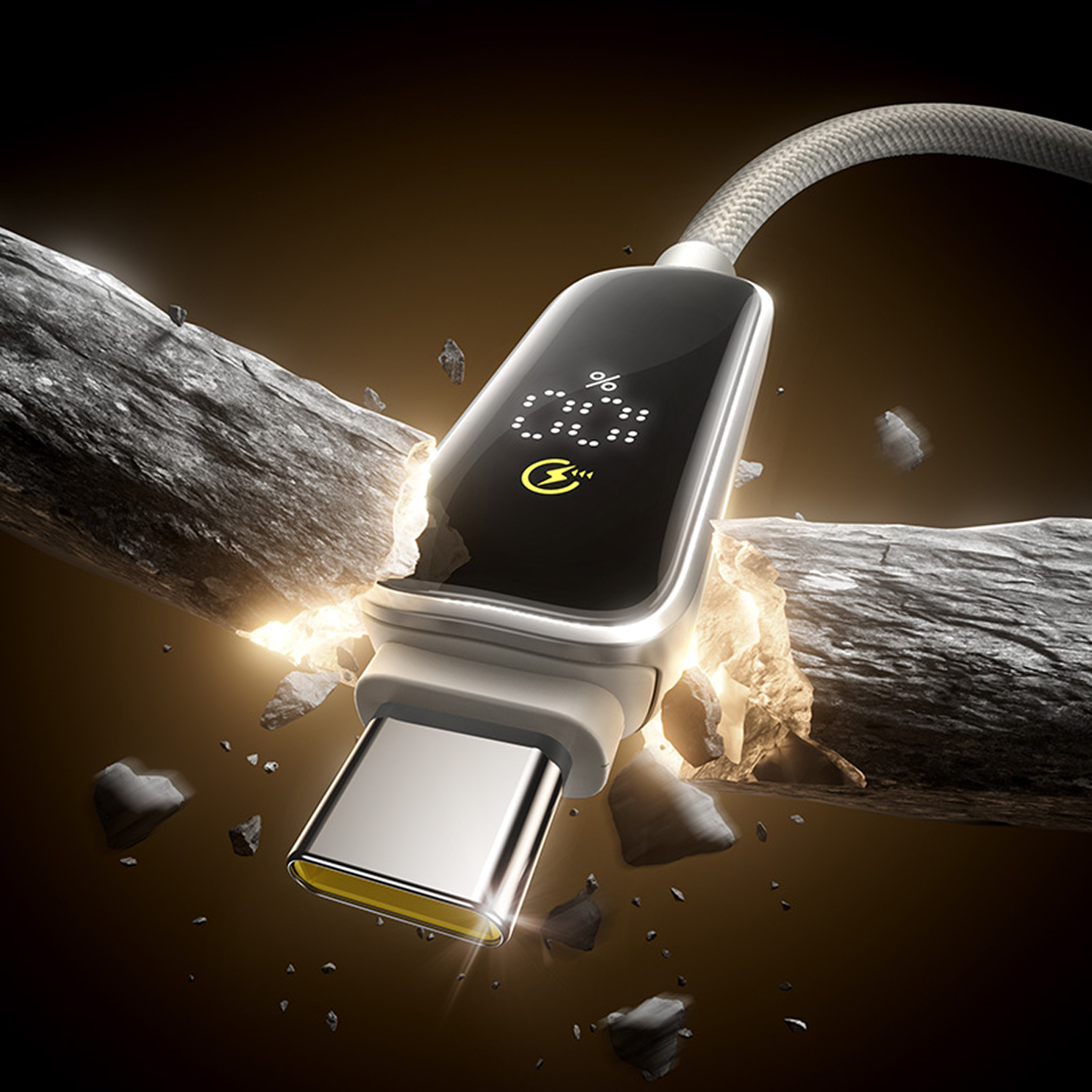 Un cable de carga USB-C rompe una roca. El cable muestra el porcentaje de batería. Cable gris, conector plateado y pantalla negra.