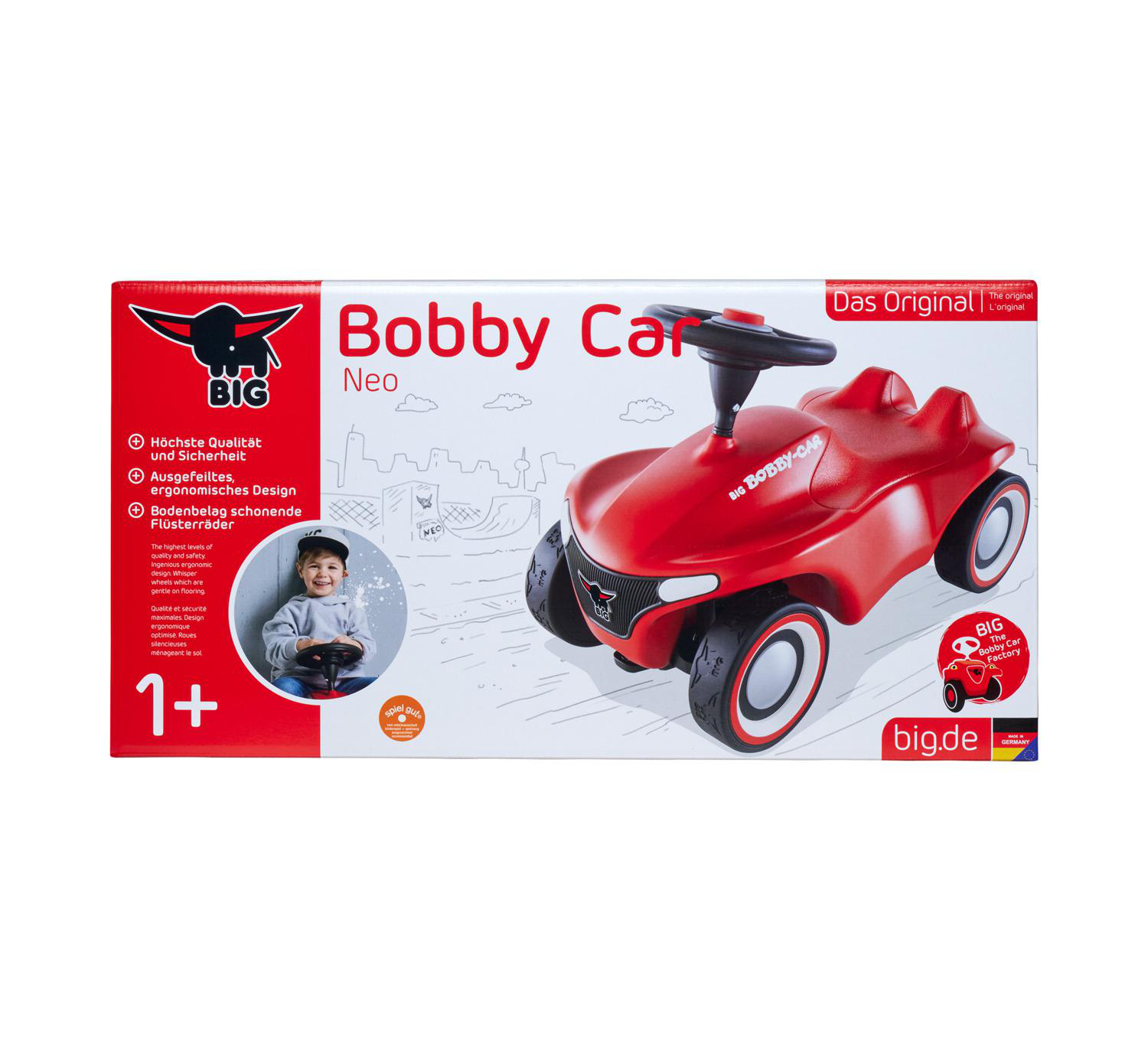 Ein rotes Bobby Car Spielzeug in einer Box. Es hat schwarze Räder mit weißen Felgen und ein schwarzes Lenkrad. Ein Kind ist abgebildet.
