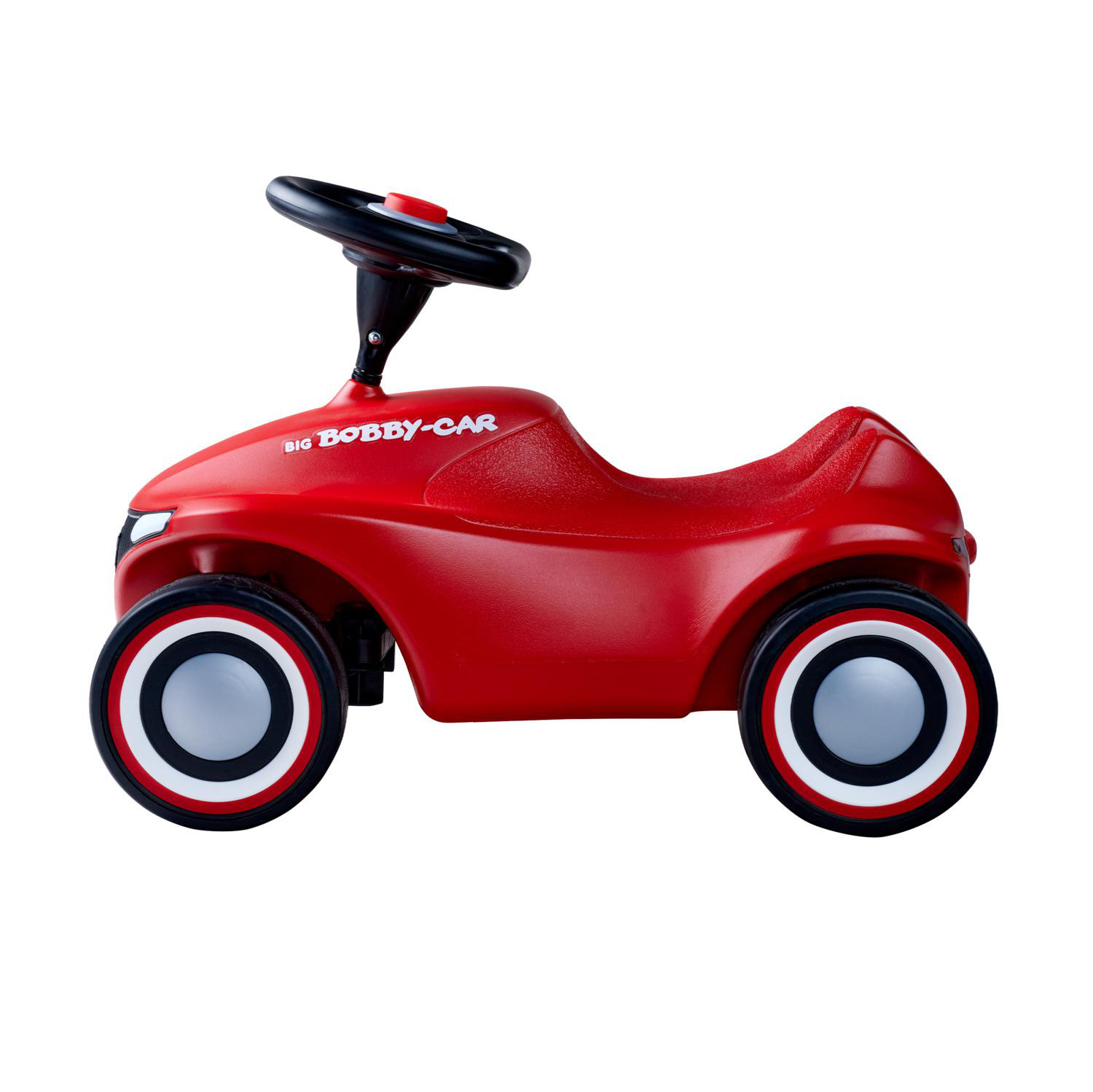 Ein rotes Big Bobby-Car Spielzeugauto mit schwarz-weißen Rädern, einem schwarzen Lenkrad und weißem Hintergrund.