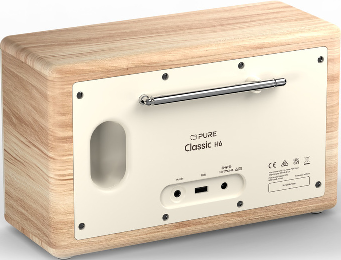 Une radio en bois avec un panneau arrière crème. Elle possède une antenne rétractable et plusieurs ports, dont USB et Aux In.