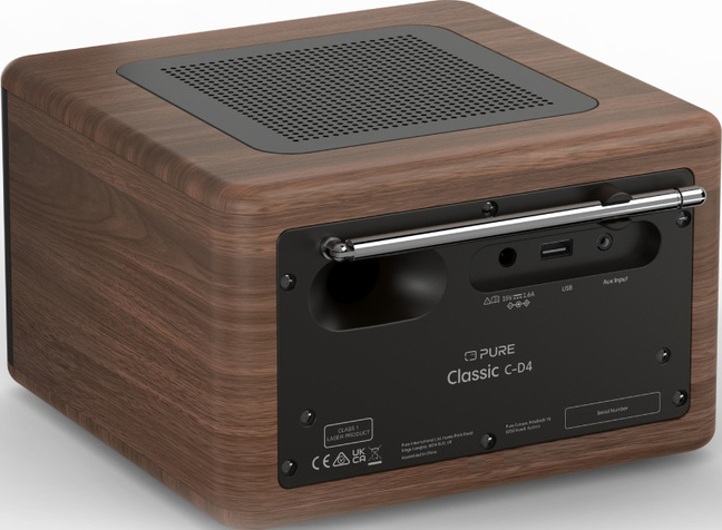 Radio en bois, vue arrière. Grille noire en haut. Panneau noir avec entrées et logo. Antenne argentée. USB et aux présents.
