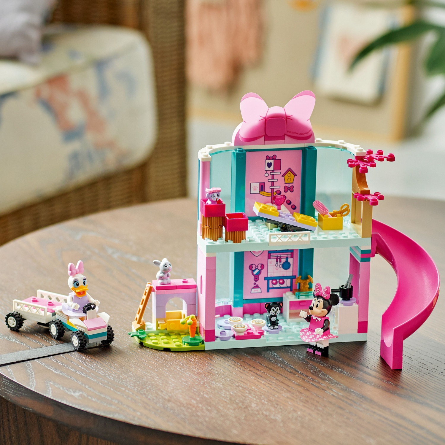 Une maison Lego avec Minnie Mouse, Daisy Duck conduisant une charrette et un toboggan rose. Comprend des accessoires et une figurine de chat.