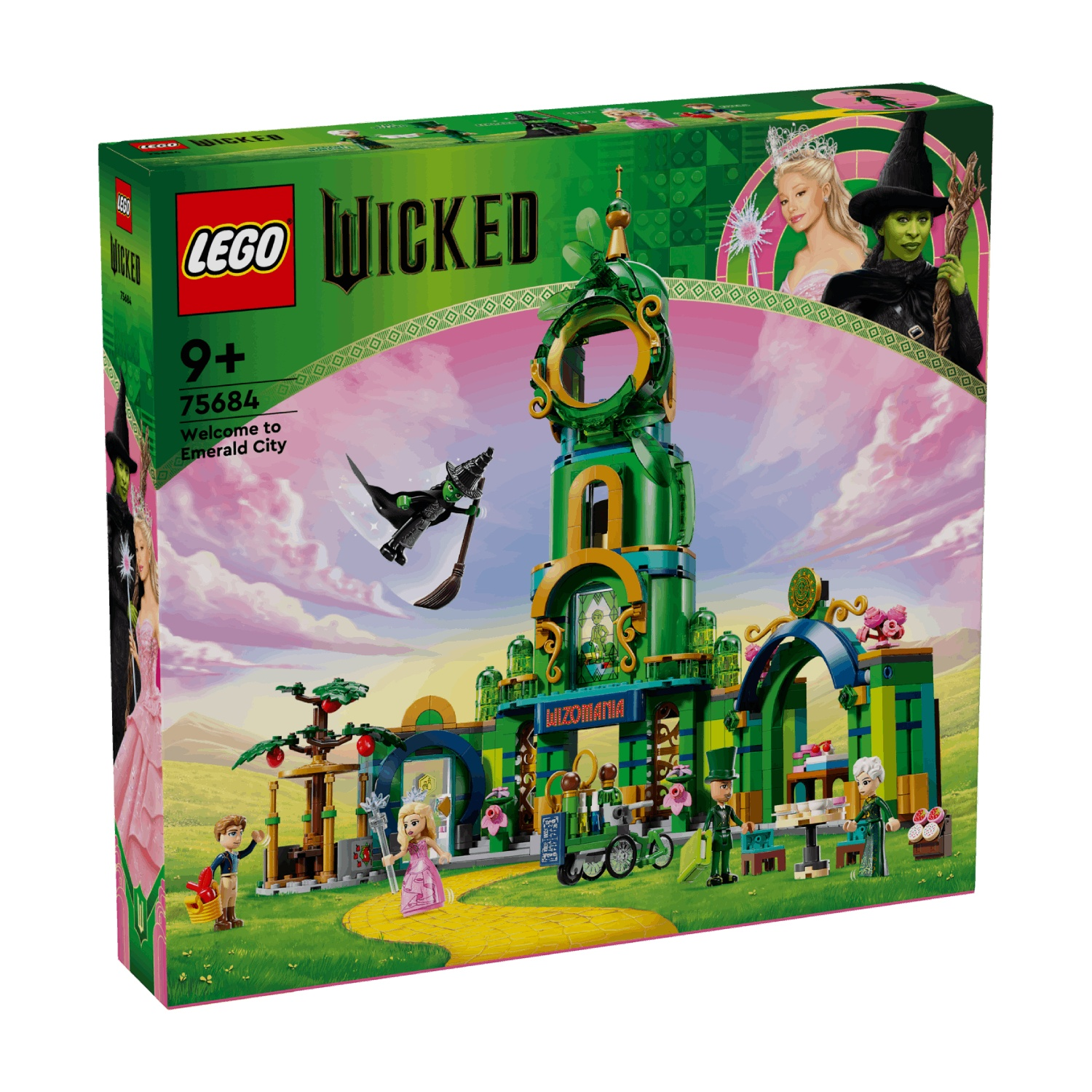 Lego Wicked box art. It depicts a green city scene with characters and structures in a fairytale setting with a pink sky.