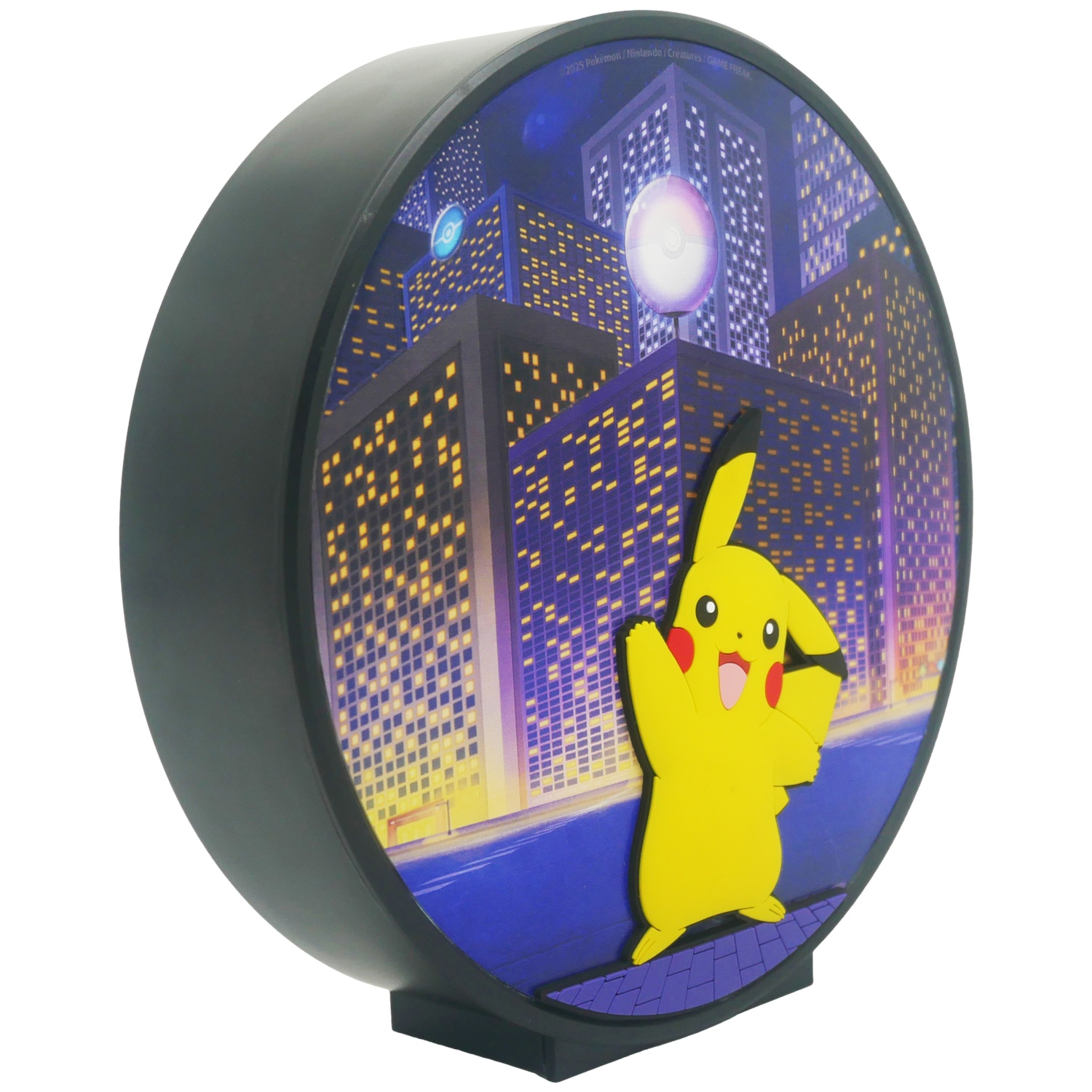 A round Pikachu night light. Pikachu is in front of a city background. It is smiling and waving.