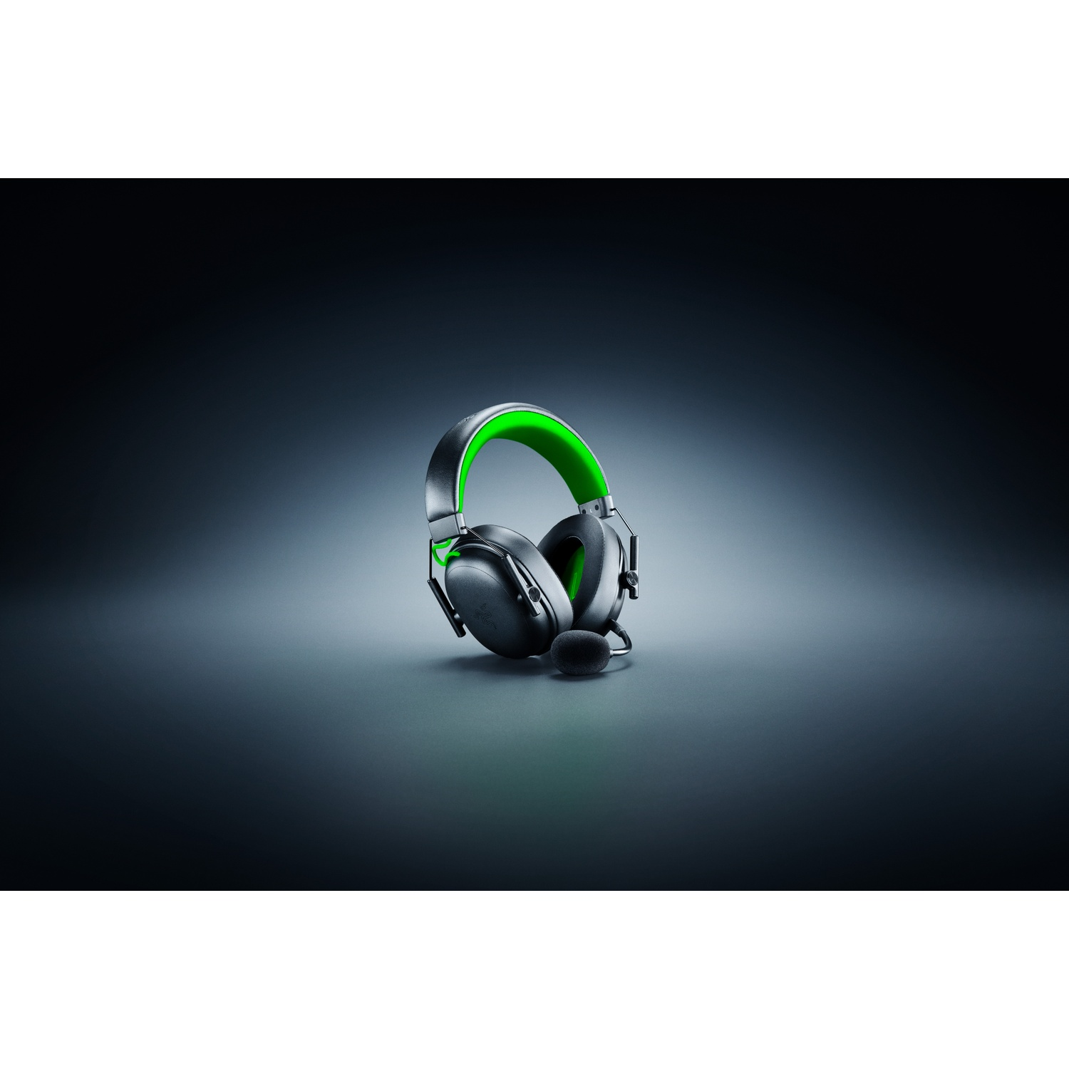 Black and green gaming headset with a microphone, set against a dark gradient background. The headset is centered.